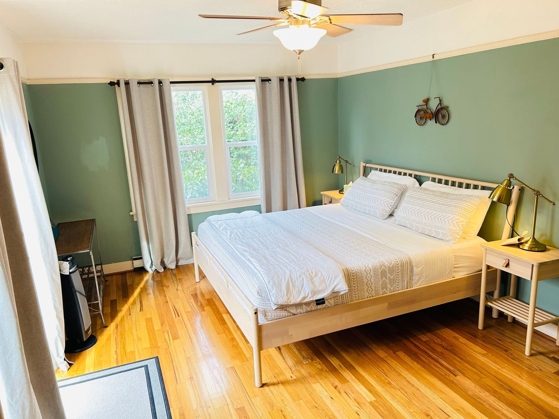 A bedroom with a king size bed and a ceiling fan.