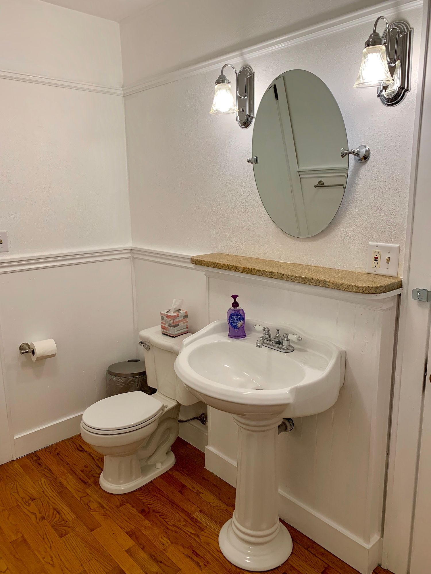 A bathroom with a toilet , sink and mirror