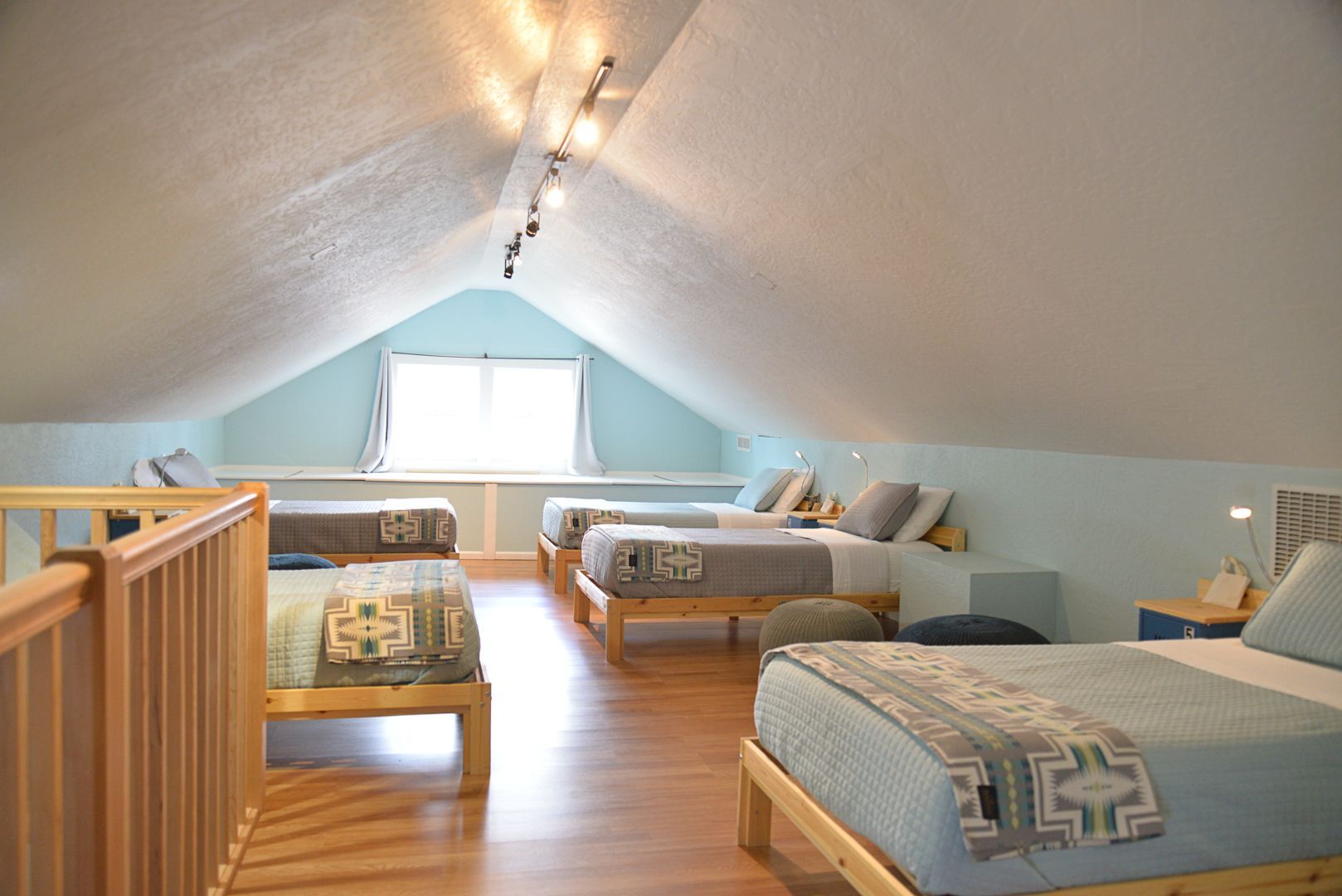 There are four beds in the attic of a house.