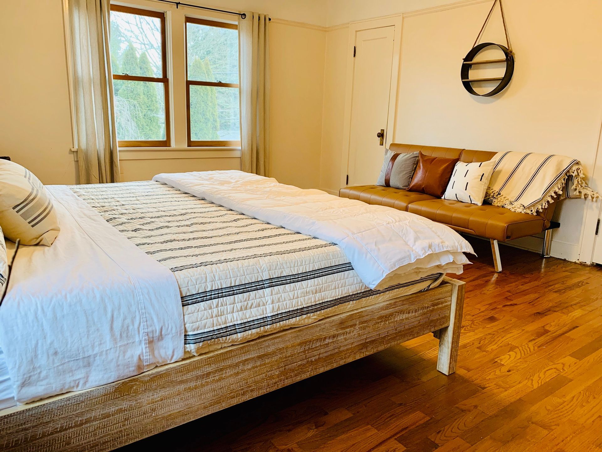A bedroom with a bed , couch , and window.