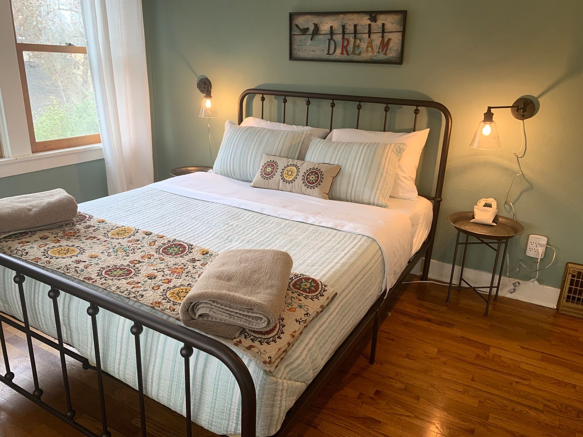 A bedroom with a bed , nightstand , and window.