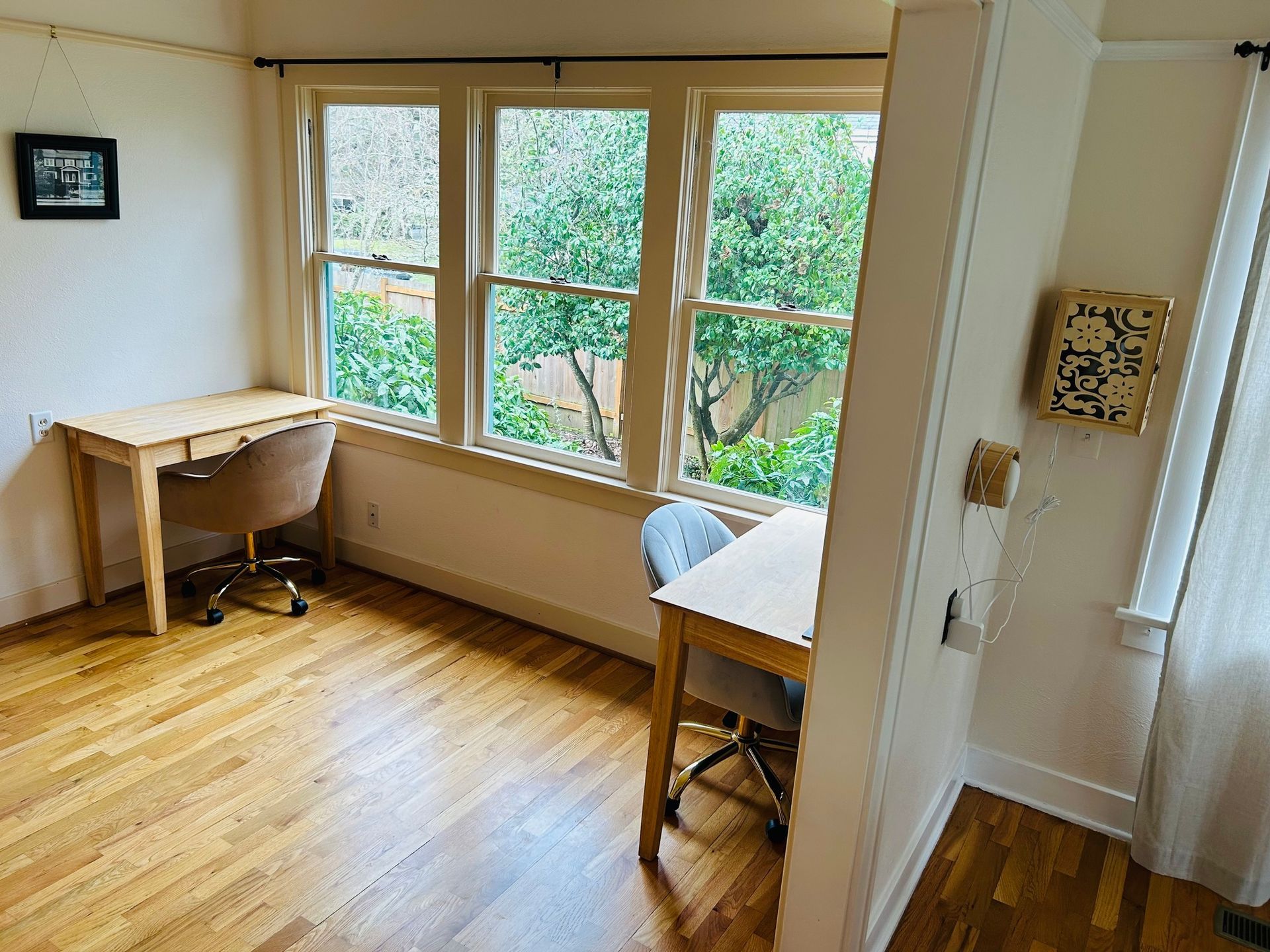A room with a desk , chair , and window.