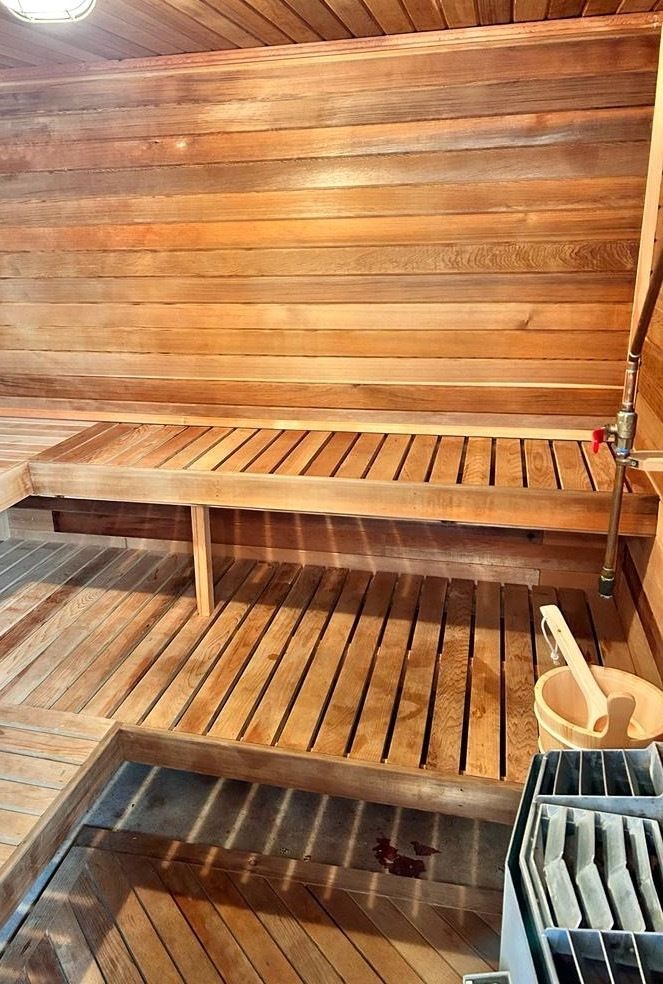 A wooden sauna with a wooden bench and a wooden bucket.