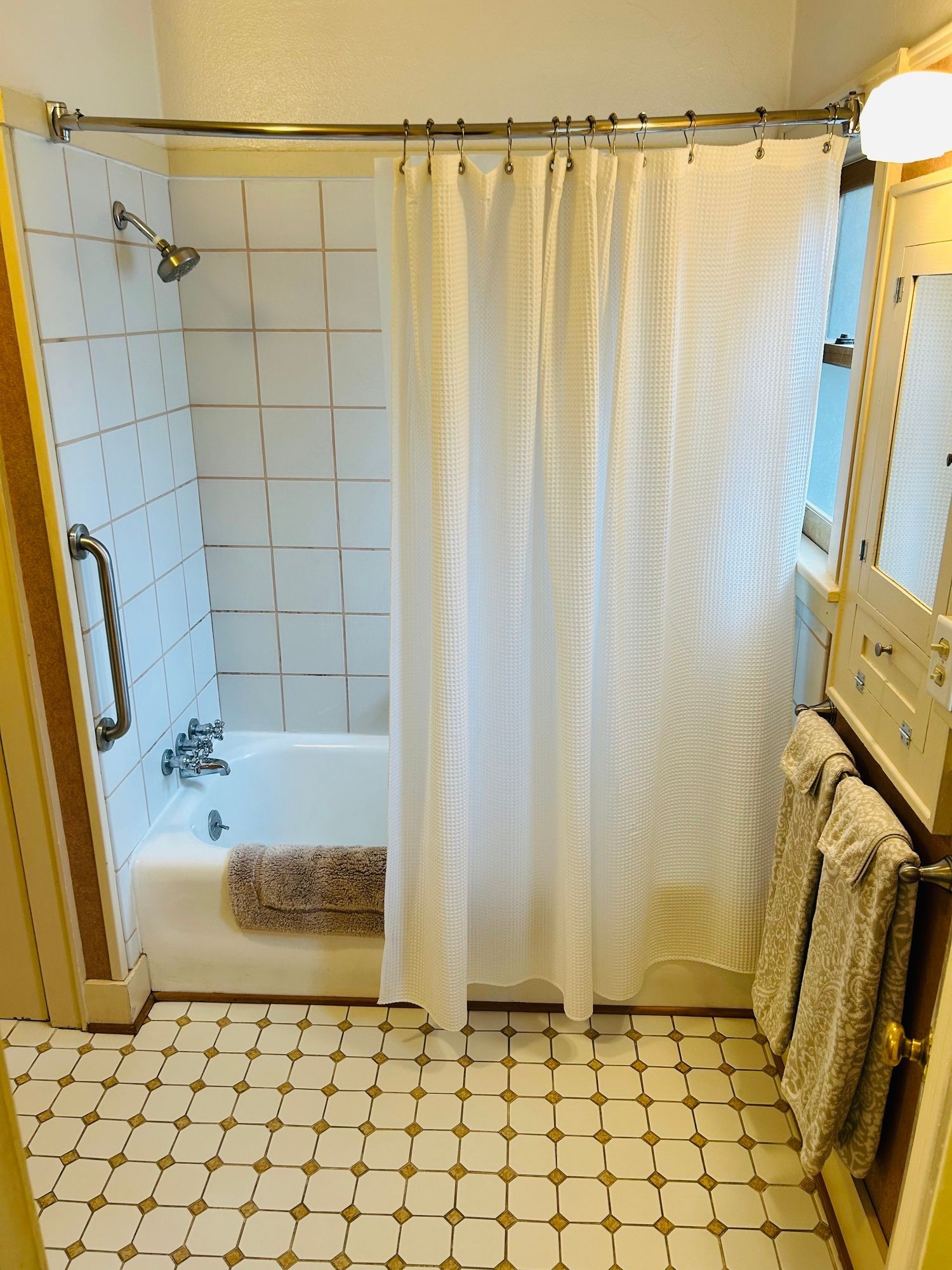 A bathroom with a white shower curtain and a bathtub.