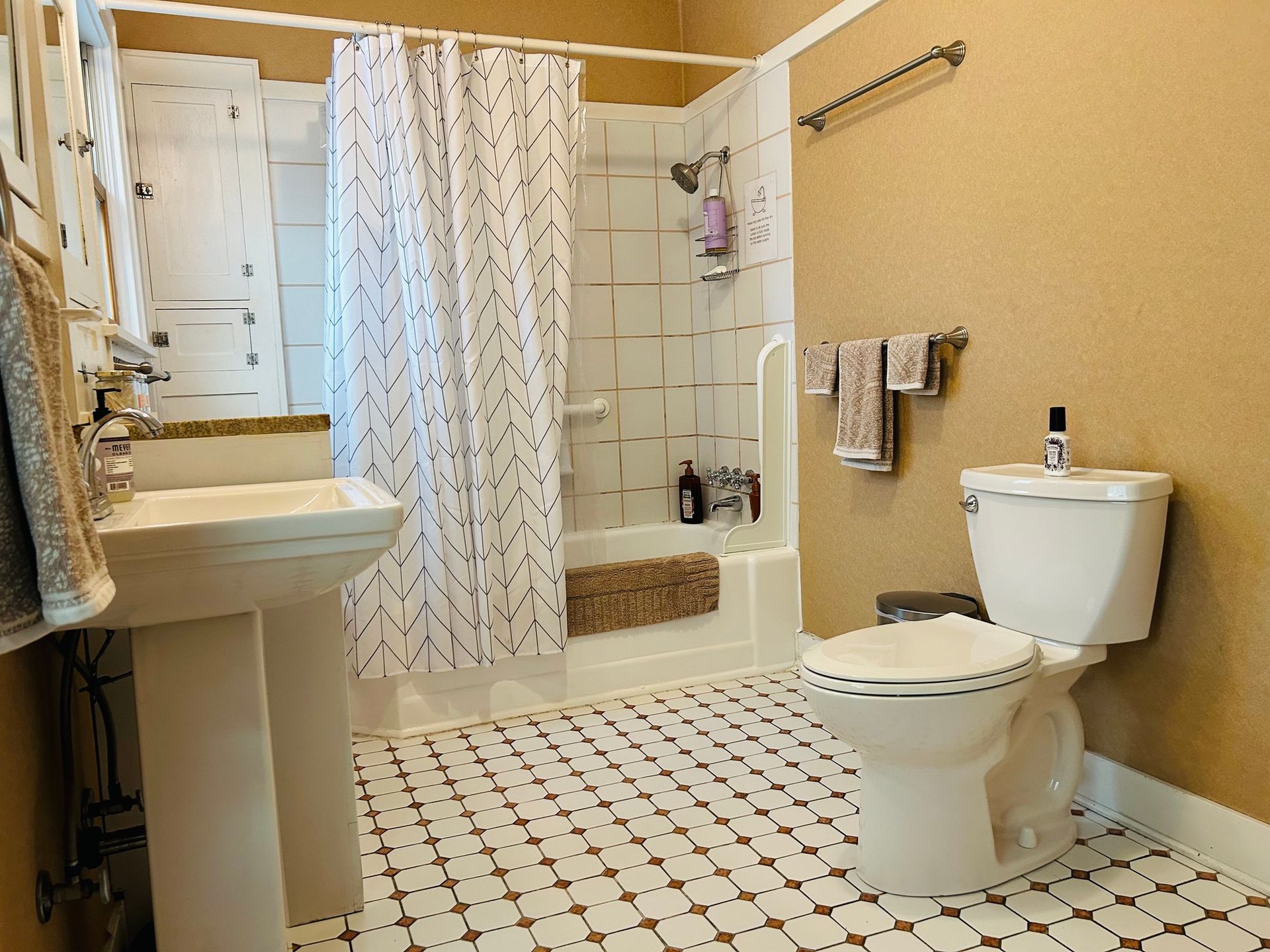A bathroom with a toilet , sink , and shower.