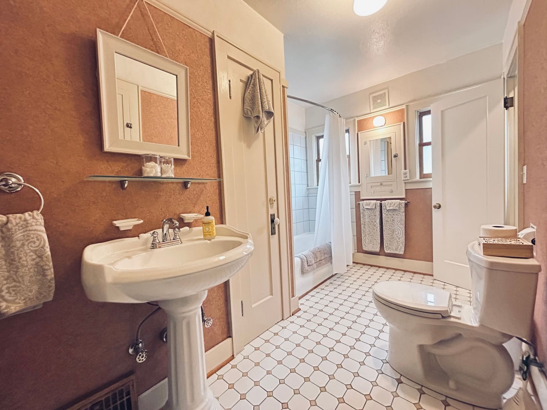A bathroom with a sink , toilet and mirror.