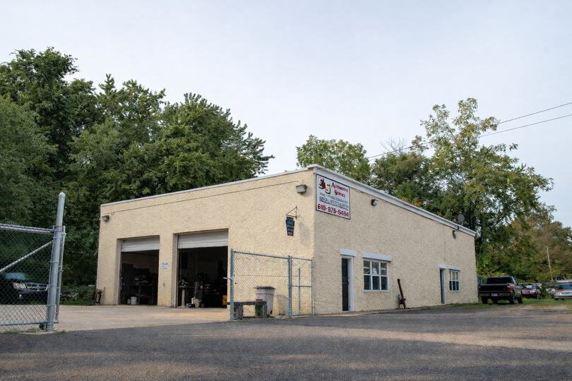 Exterior view of a S&S Automotive Services shop in Upland, PA with two garage doors open.