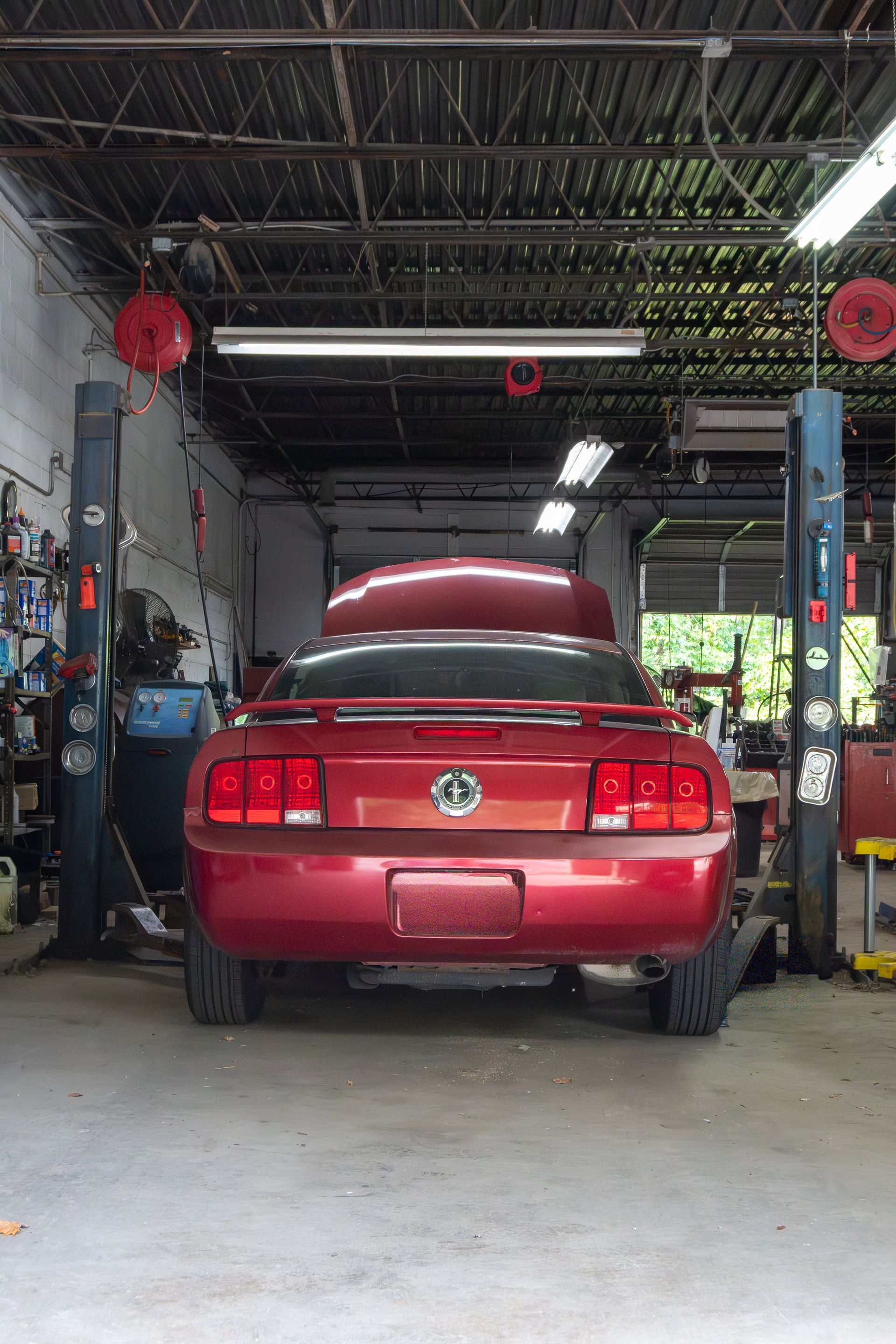 Red Ford Mustang on a lift inside S&S Automotive Service in Upland, PA.