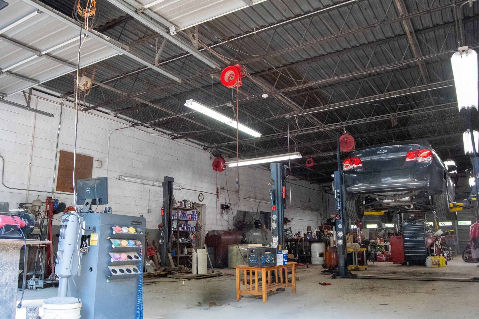 S&S Automotive Service shop interior with a car on a lift, tools, and equipment.