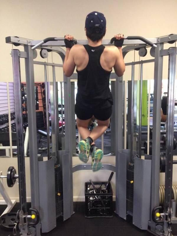 A Man Is Doing a Pull up In a Gym — Maxenergy Fitness In Smithfield, QLD