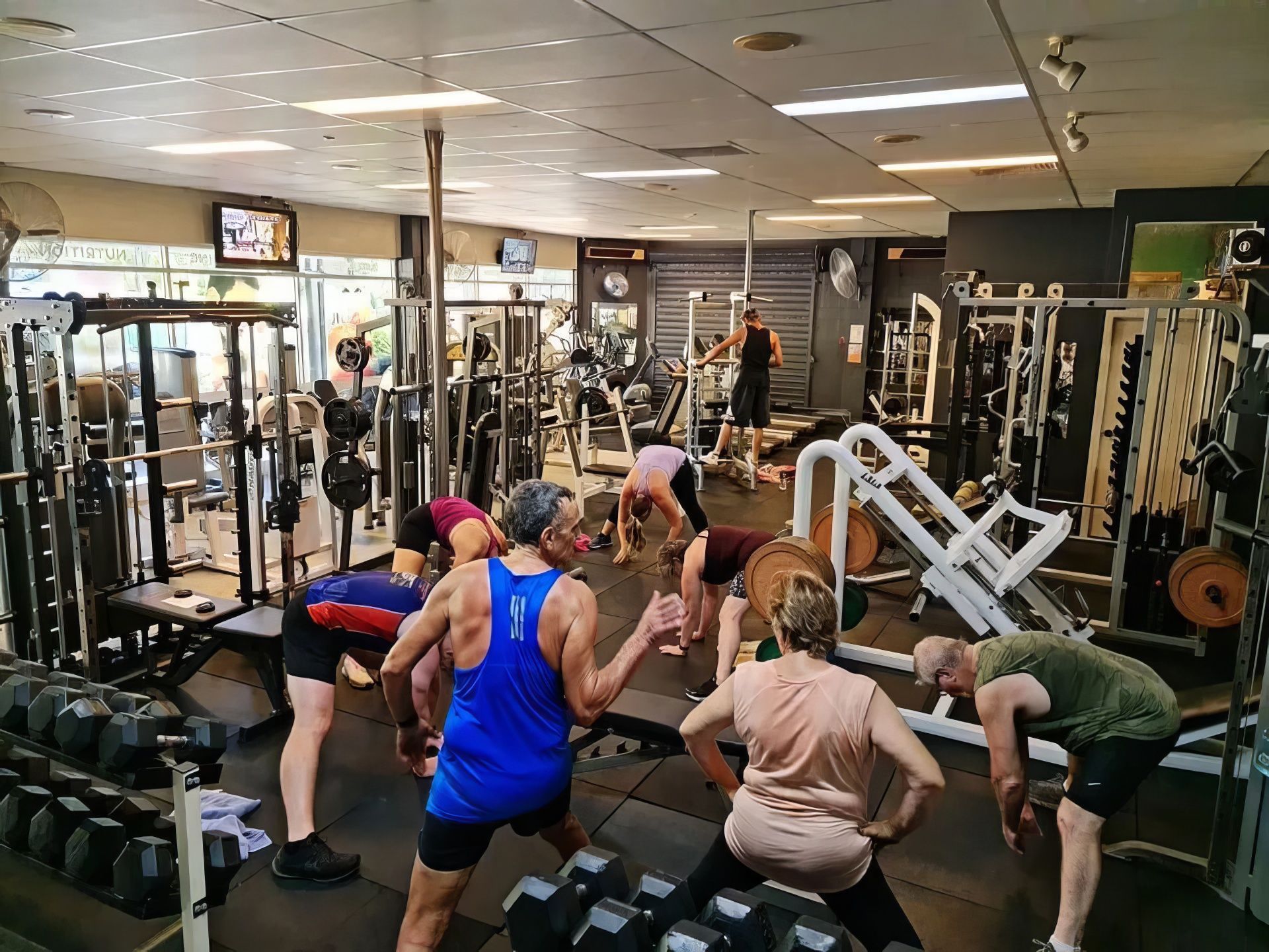 A Group of People Are Doing Stretching Exercises in A Gym — Maxenergy Fitness In Smithfield, QLD