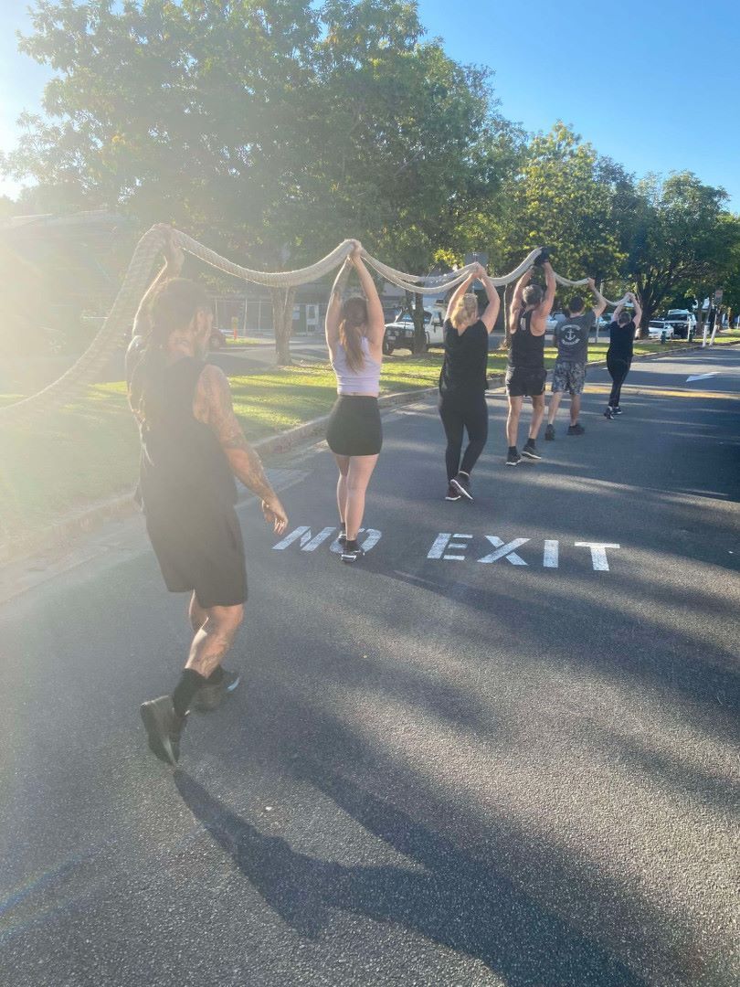 A Group Of People Holding Up A Rope  On The Side Of The Road — Maxenergy Fitness in Smithfield, QLD