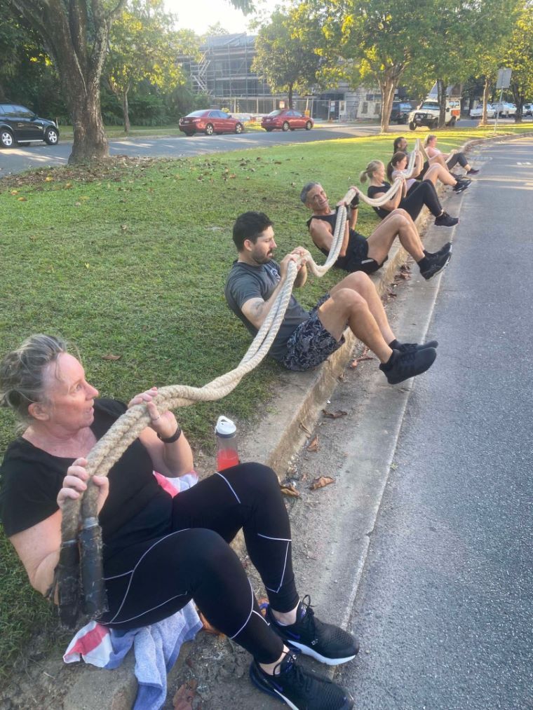 A Group Of People Holding Up A Rope While Sitting On The Sie Of The Road — Maxenergy Fitness in Smithfield, QLD