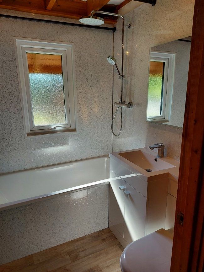 Bathroom Downstairs with Drenching Shower, fully enclosed sink, Toilet combination and Heated Towel Rail.