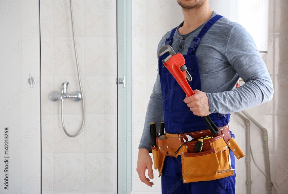 Plumber holding a pipe wrench, showcasing residential plumbing services for home repairs.