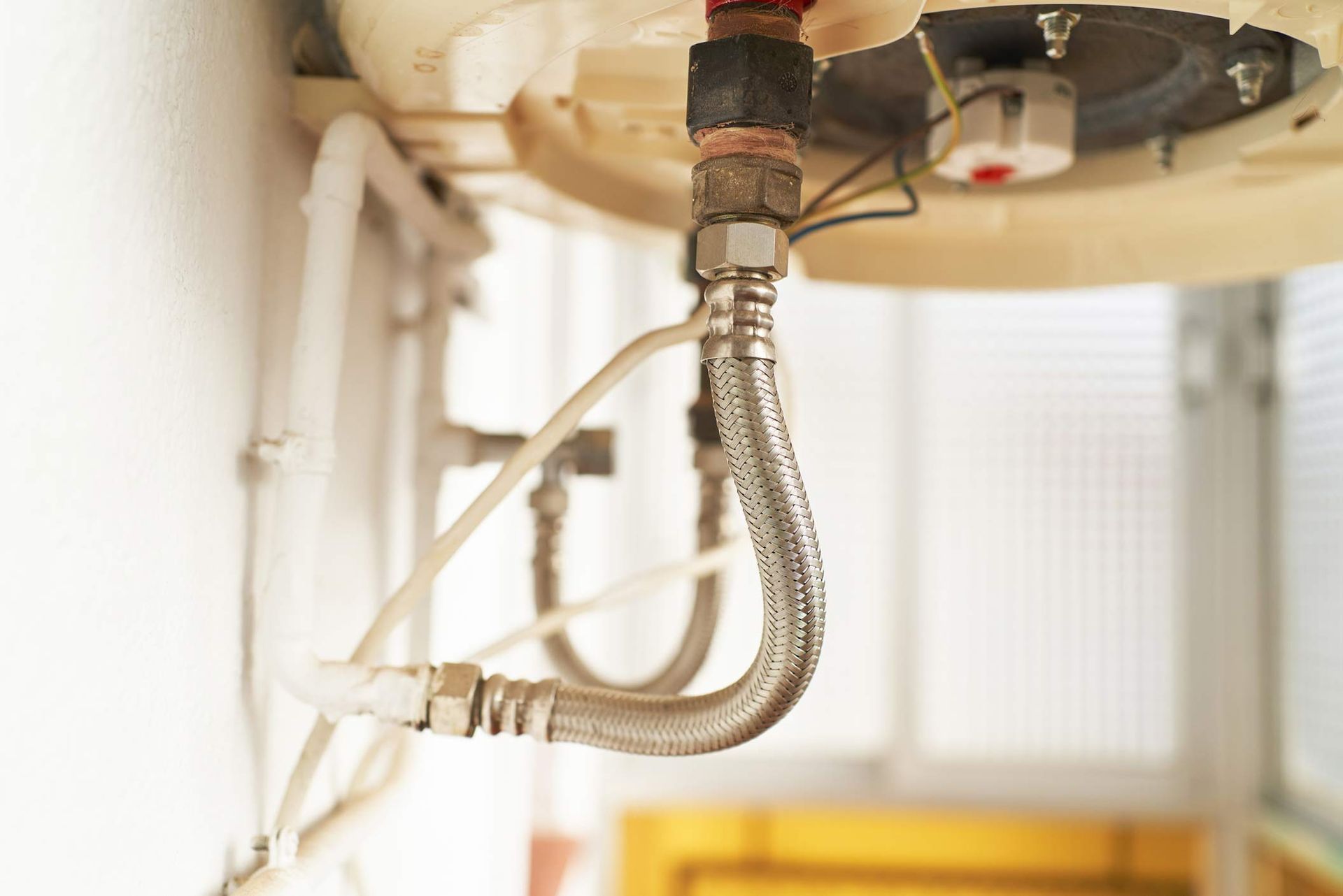 Side view of the hot and cold water supply connection under the bathroom sink.