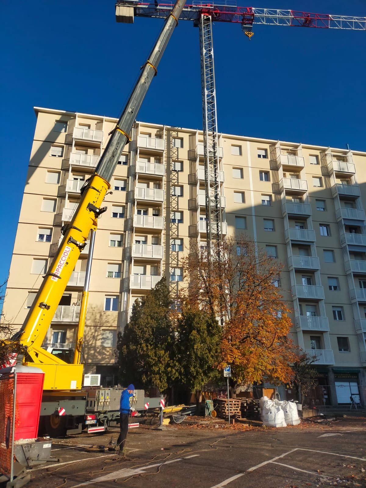 una grande gru gialla di fronte a un alto edificio.