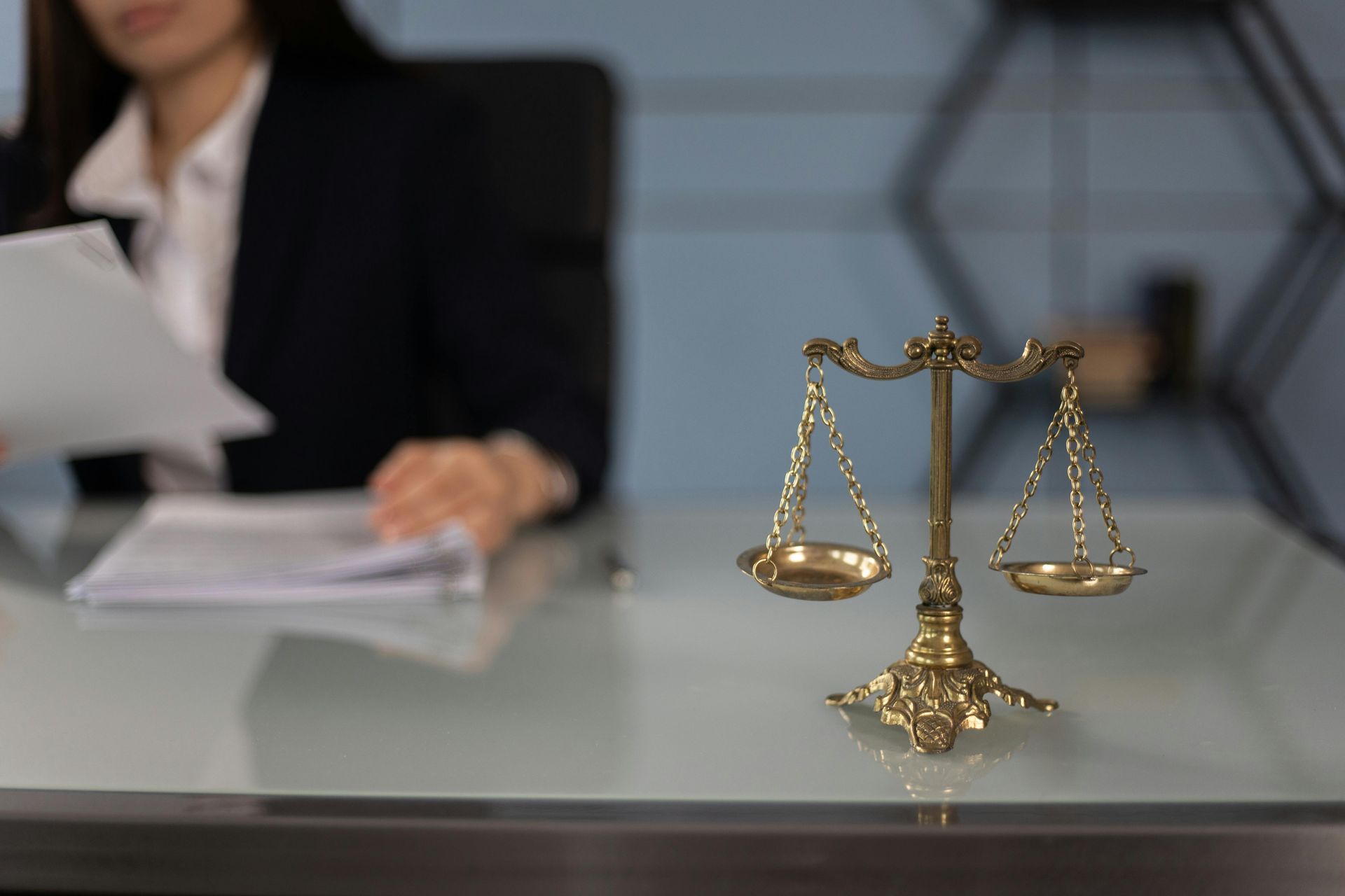 Lawyer reviewing documents; scales of justice on the desk.