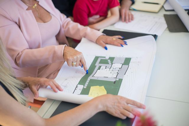 People looking at architectural plans, a woman points.
