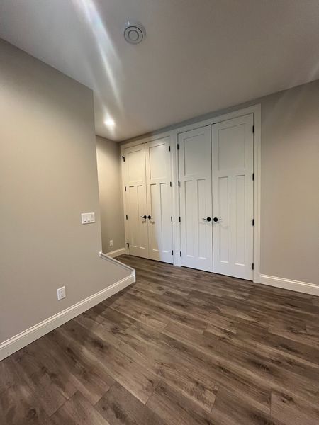 An empty room with hardwood floors and white walls.