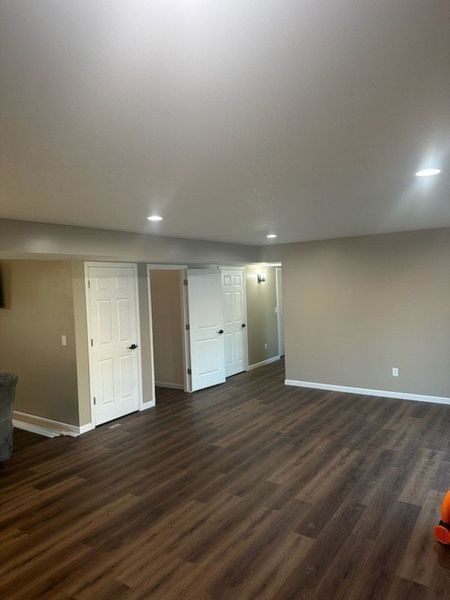 A large room with hardwood floors and a vacuum cleaner in it.