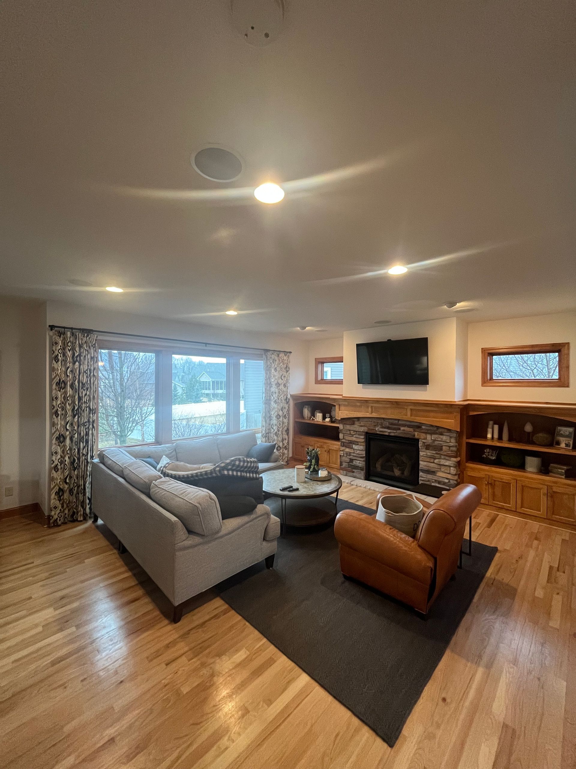 A living room with a couch , chair , coffee table and fireplace.