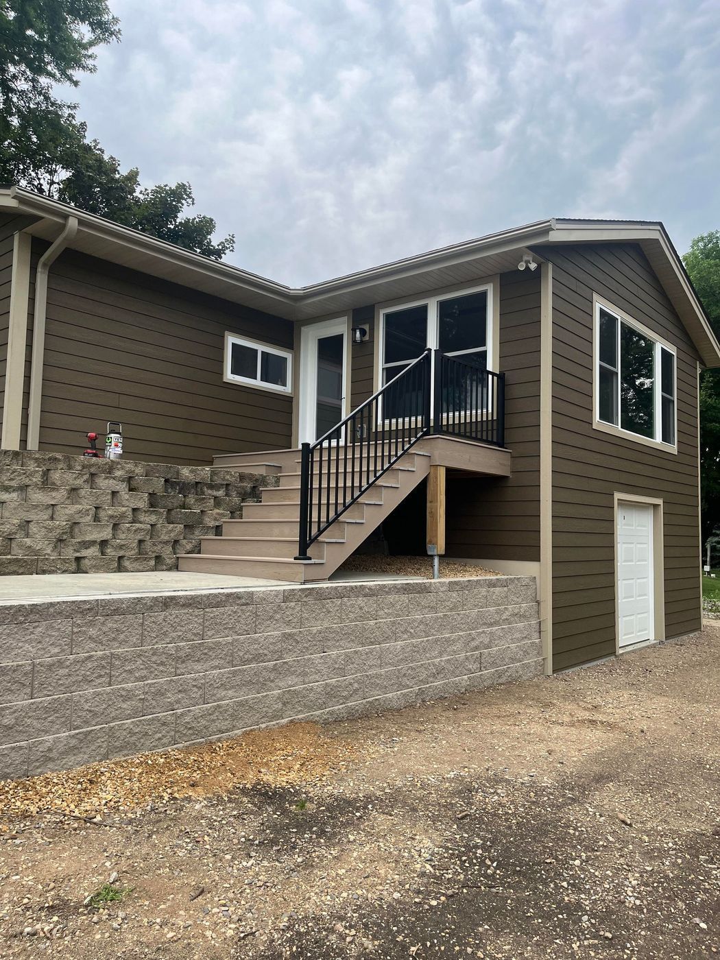 A brown house with stairs leading up to the front door