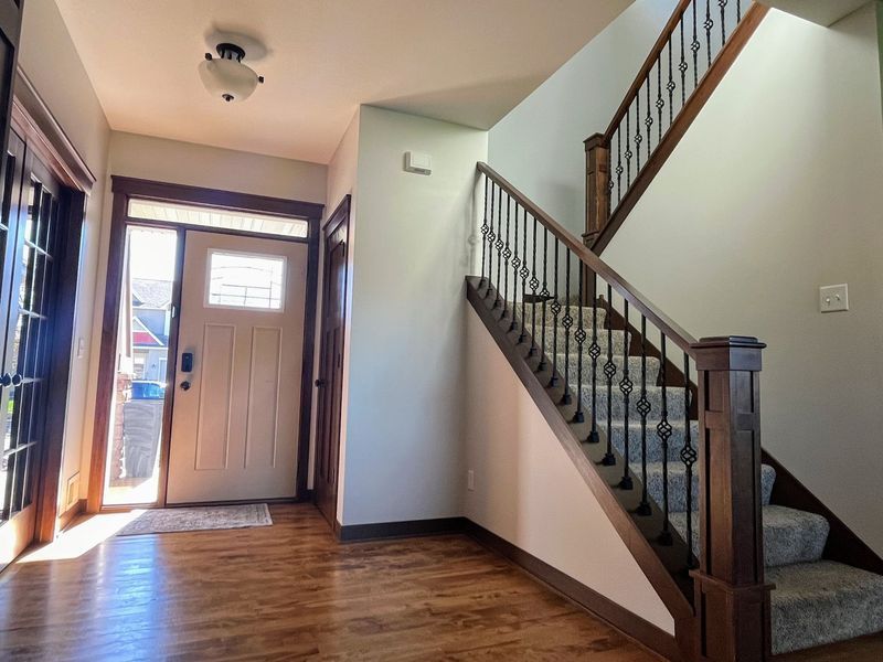 A hallway with stairs leading up to the second floor