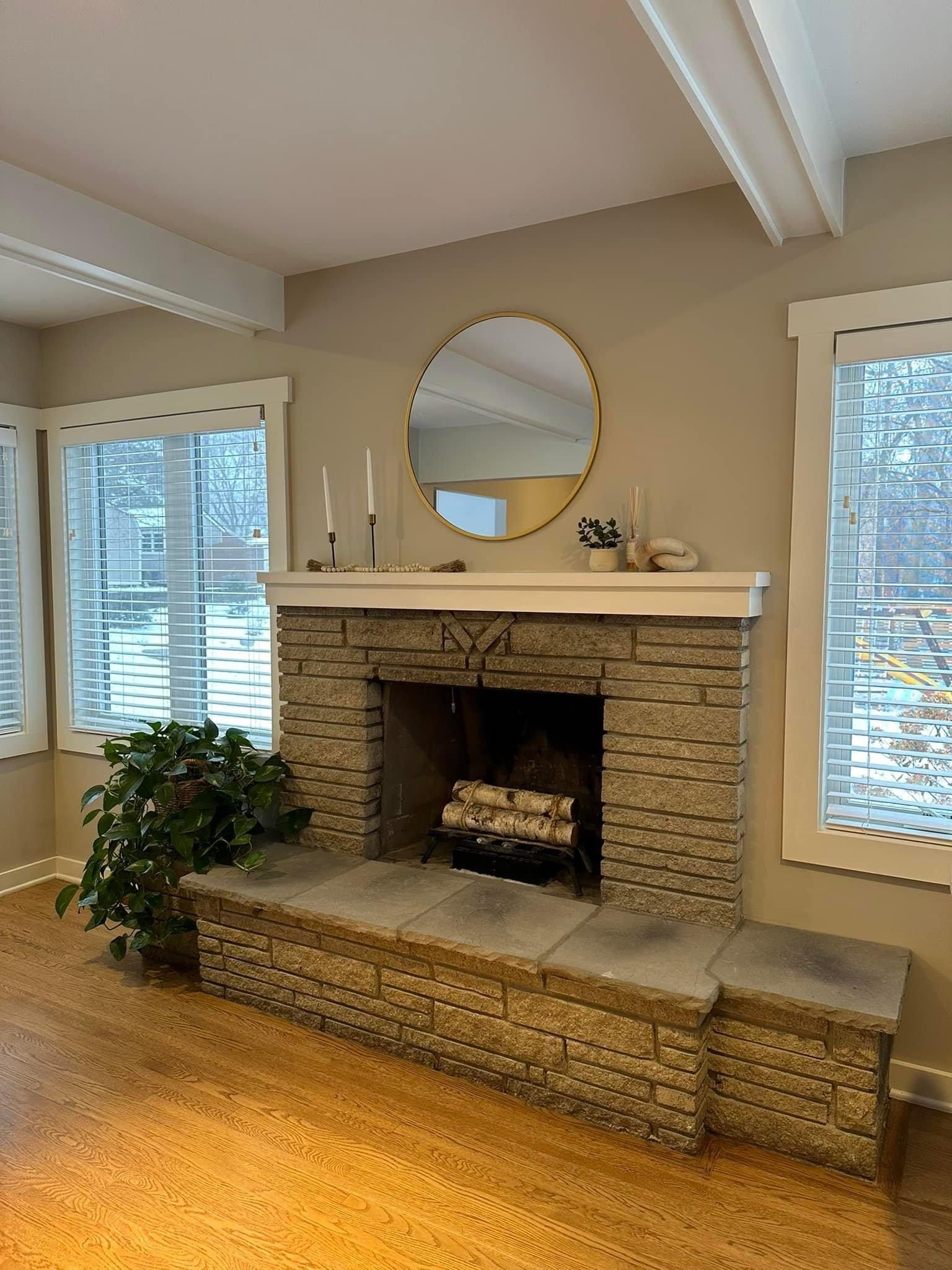 A living room with a fireplace and a mirror on the wall.