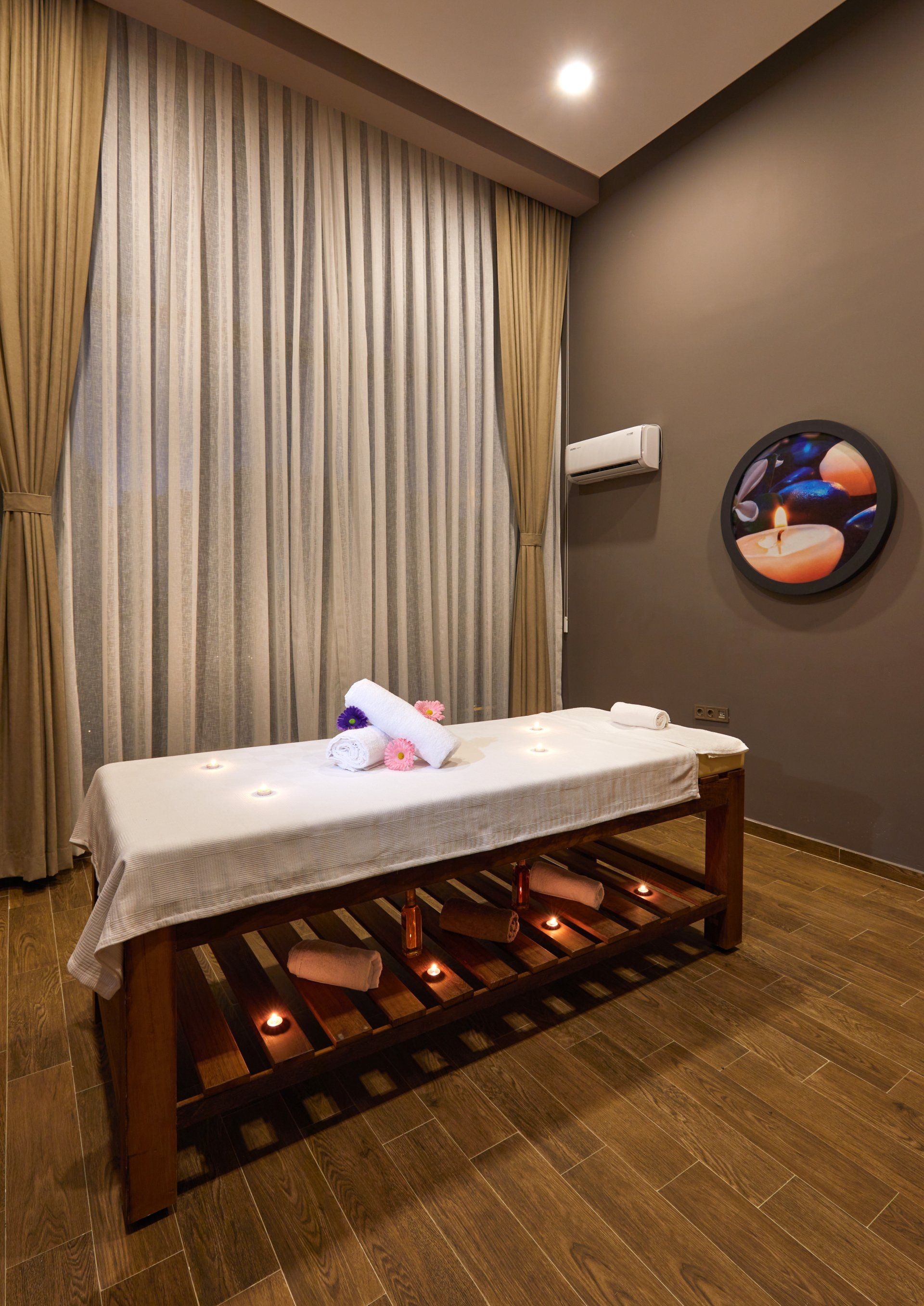 In der mitte des raumes steht eine massageliege.