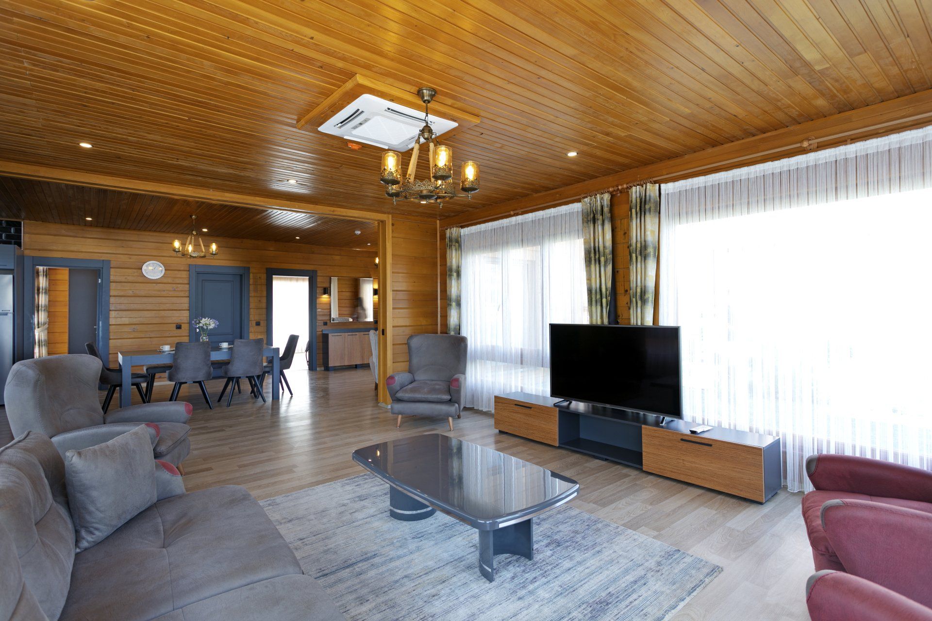 غرفة معيشة مليئة بالأثاث وجهاز تلفزيون بشاشة مسطحة.