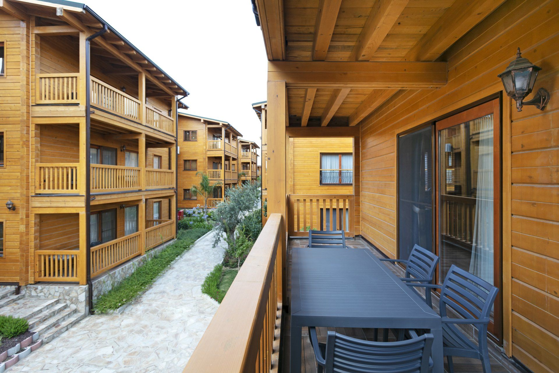 شرفة بها طاولة وكراسي أمام مبنى خشبي