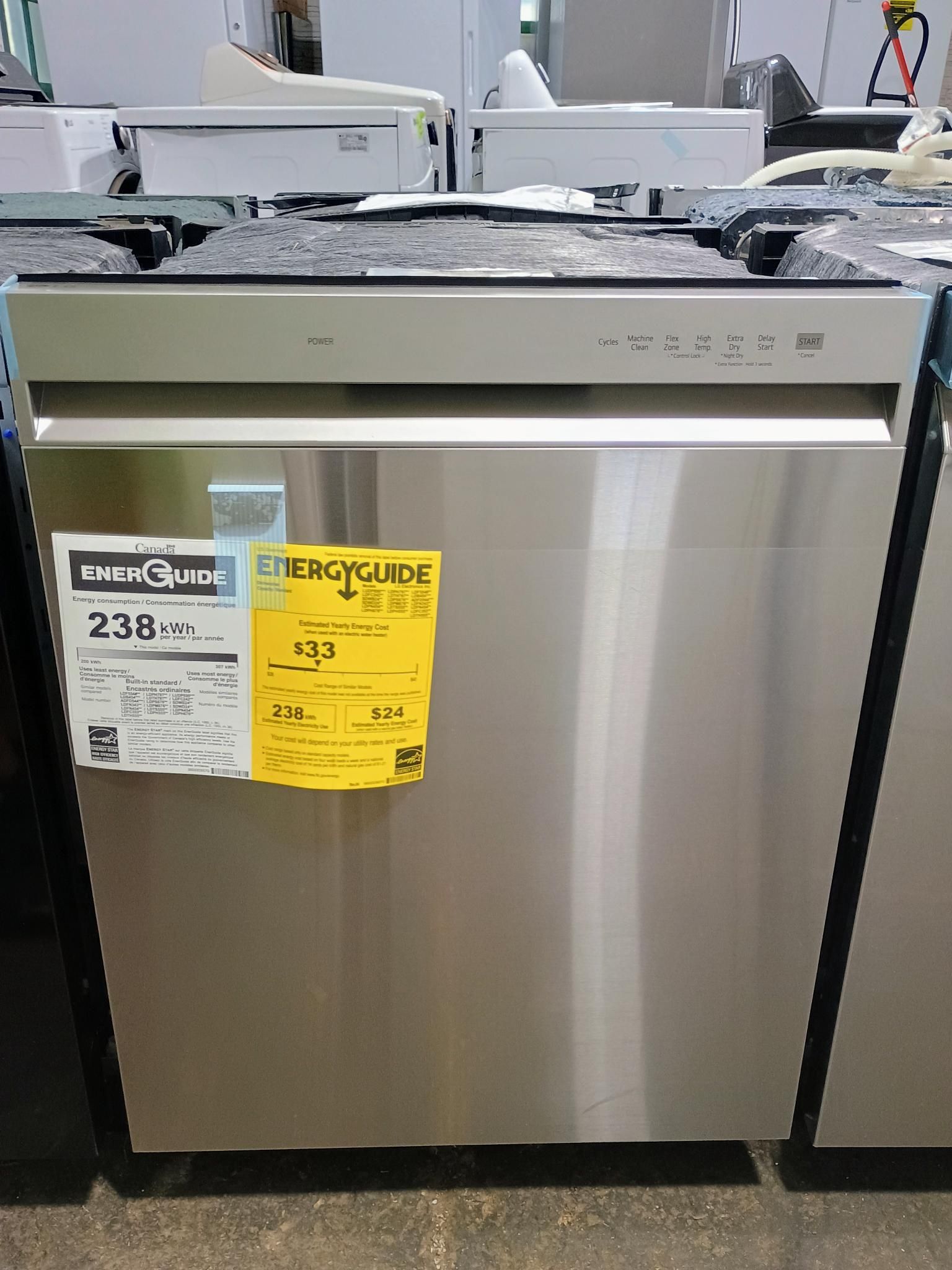A stainless steel dishwasher is sitting on a shelf in a store.