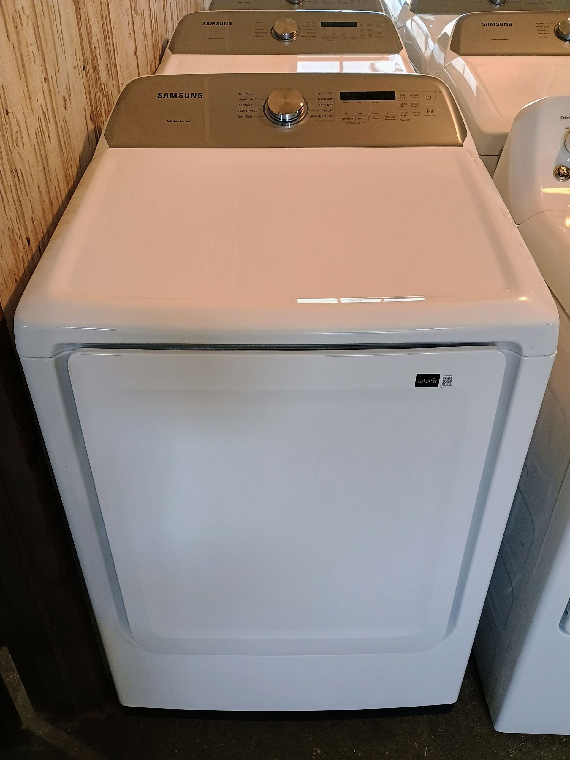 A white washer and dryer are sitting next to each other in a room.
