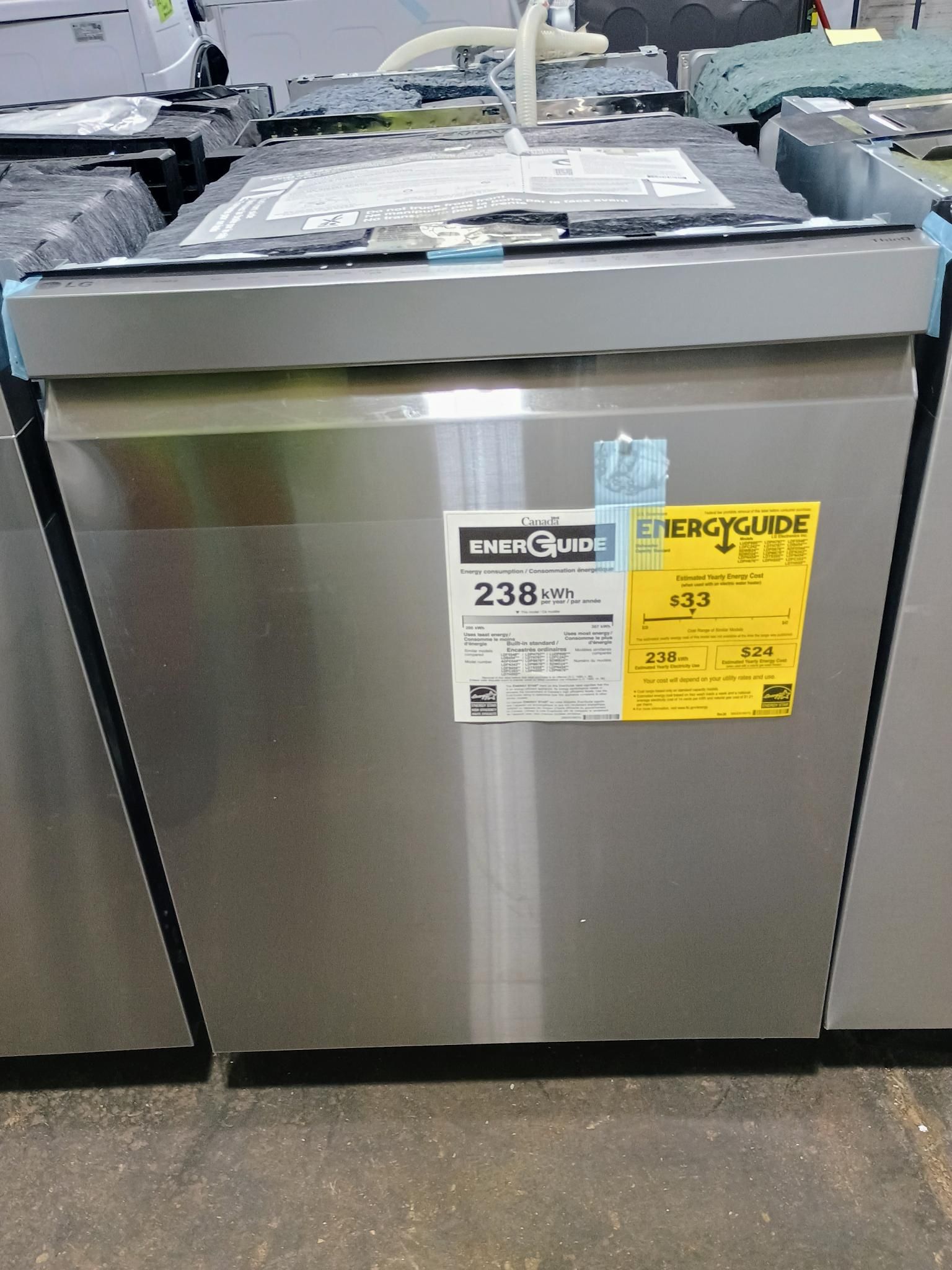 A stainless steel dishwasher is sitting on a counter in a store.