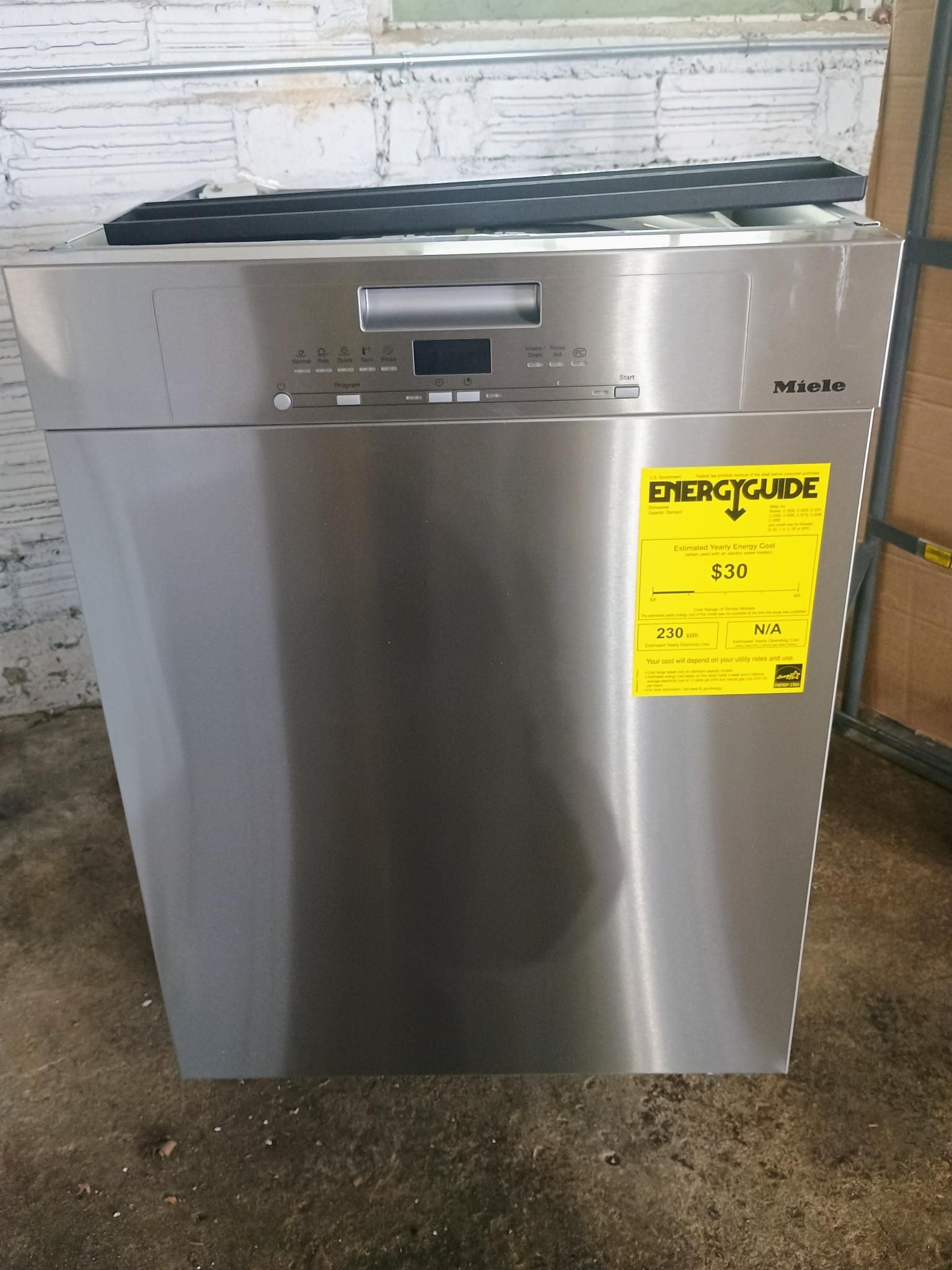 A stainless steel dishwasher with a yellow energy label on it.