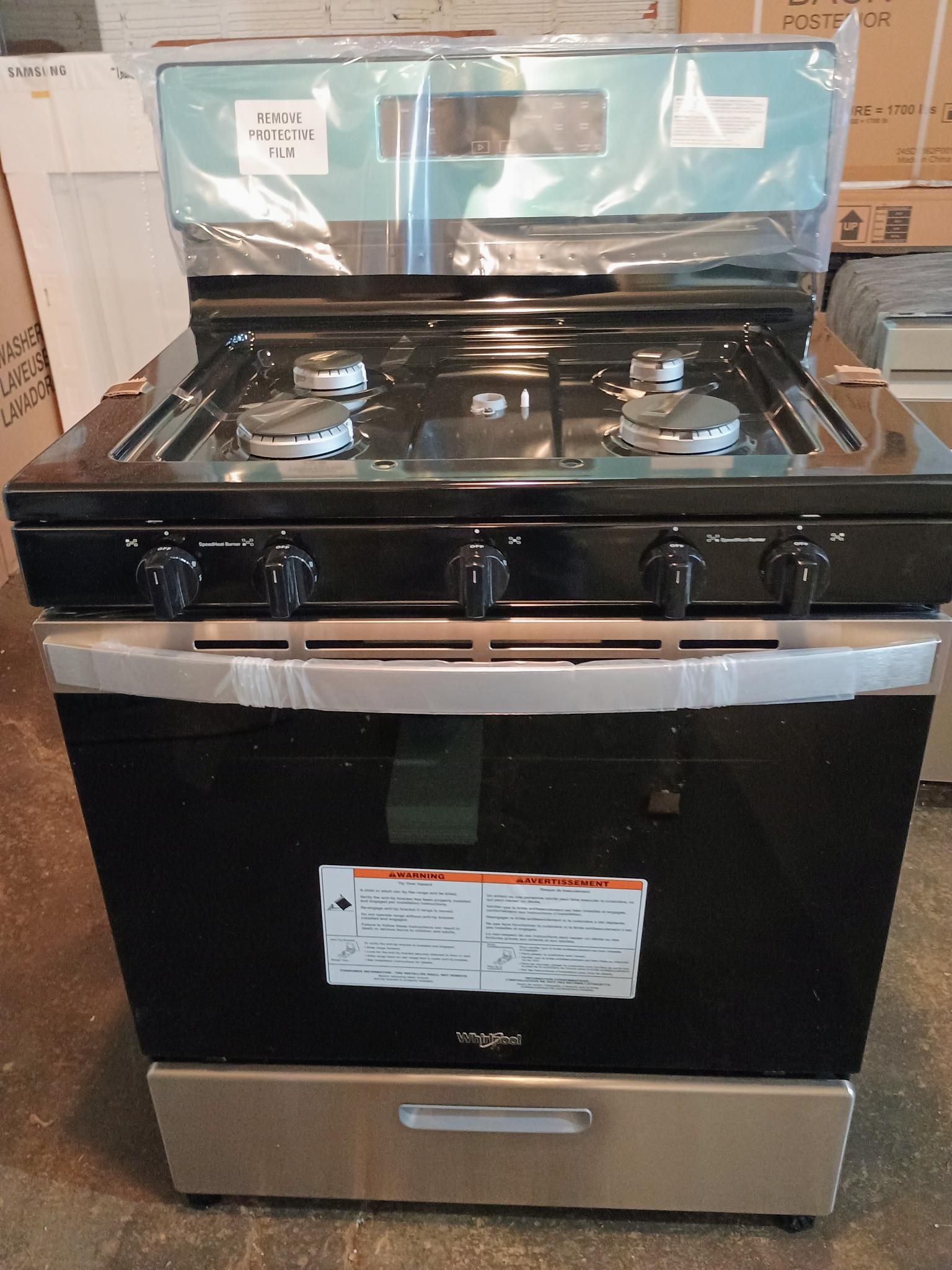 A whirlpool gas stove is sitting on the floor