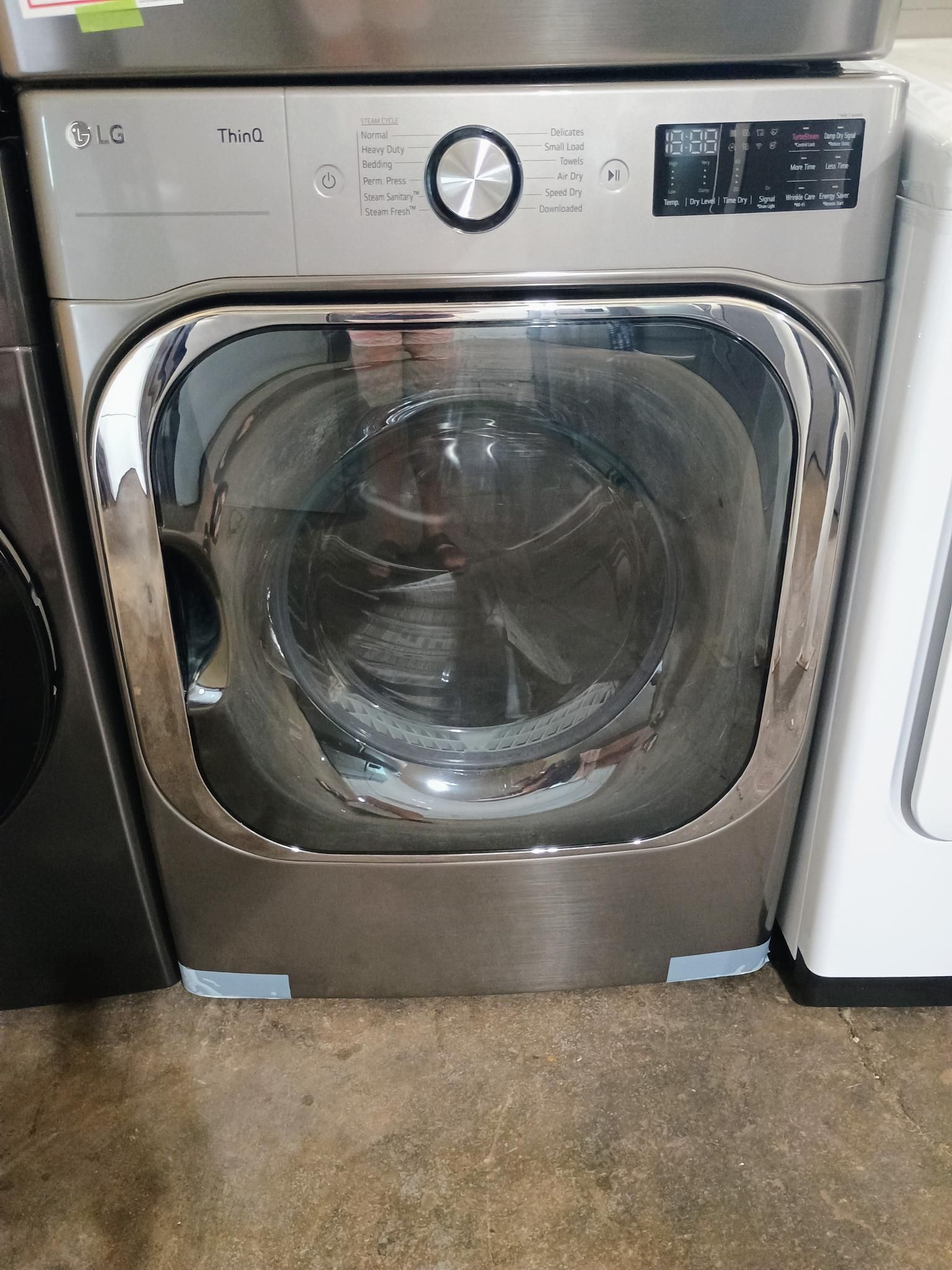 LG stainless steel front-load washing machine. Silver door, control panel, and gray body.