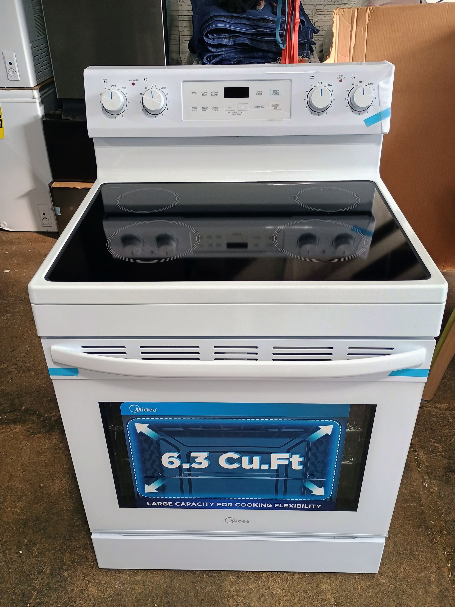 White electric range with a black glass cooktop, digital display, and a 6.3 cu. ft. oven.