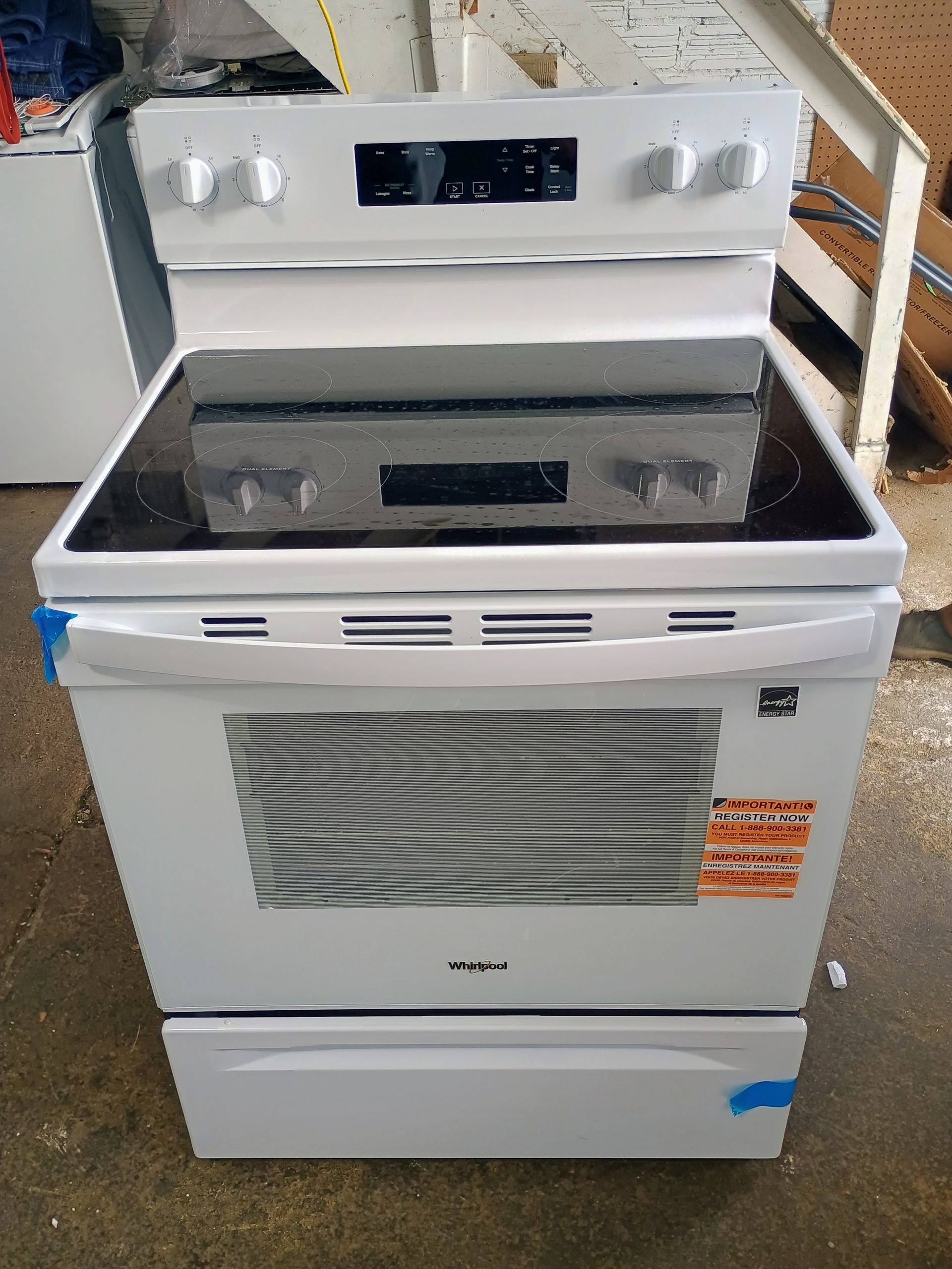 White Whirlpool electric range with black cooktop, knobs, oven door, and storage drawer.