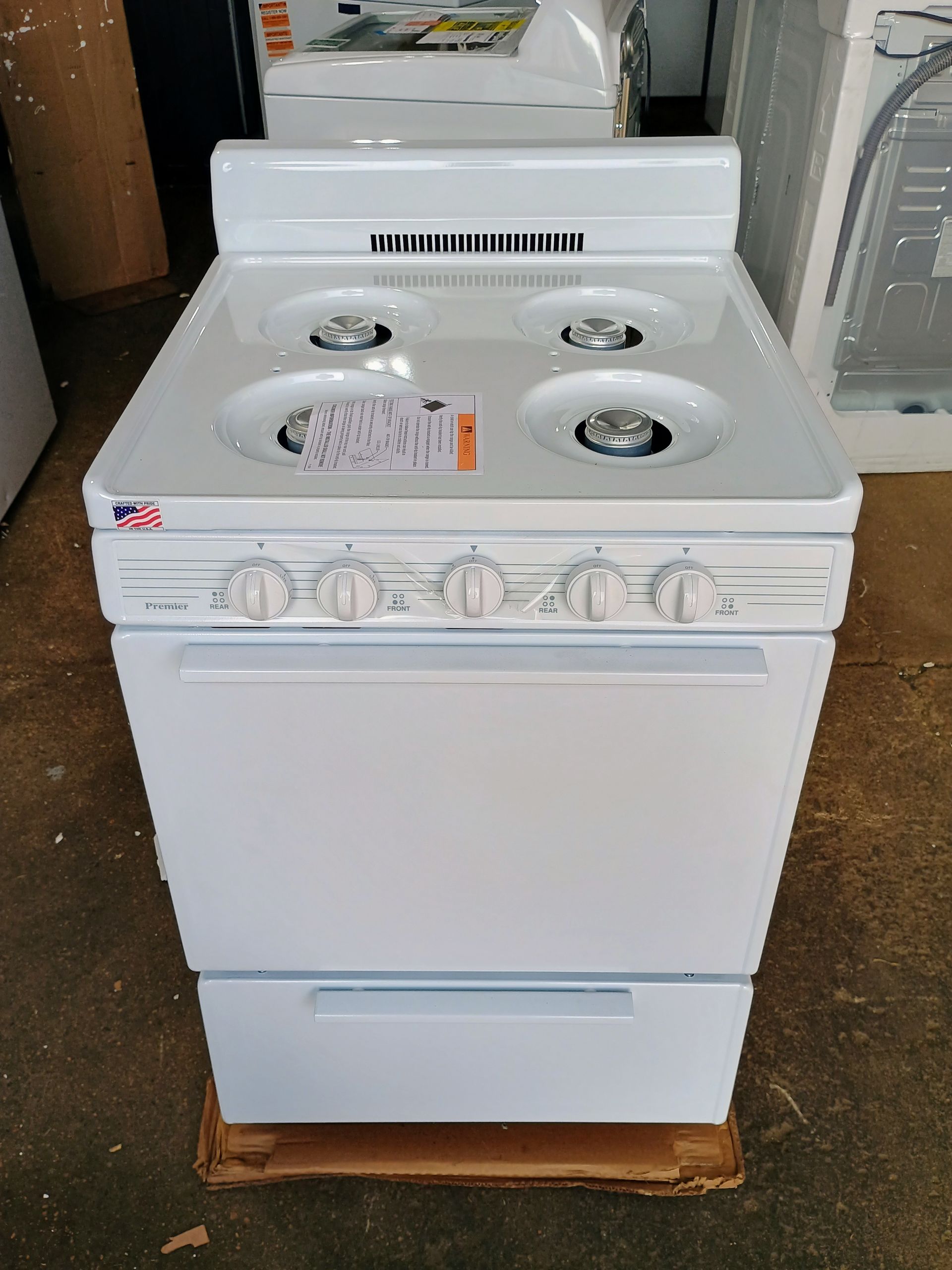 White electric stove with four burners, oven, and a storage drawer.