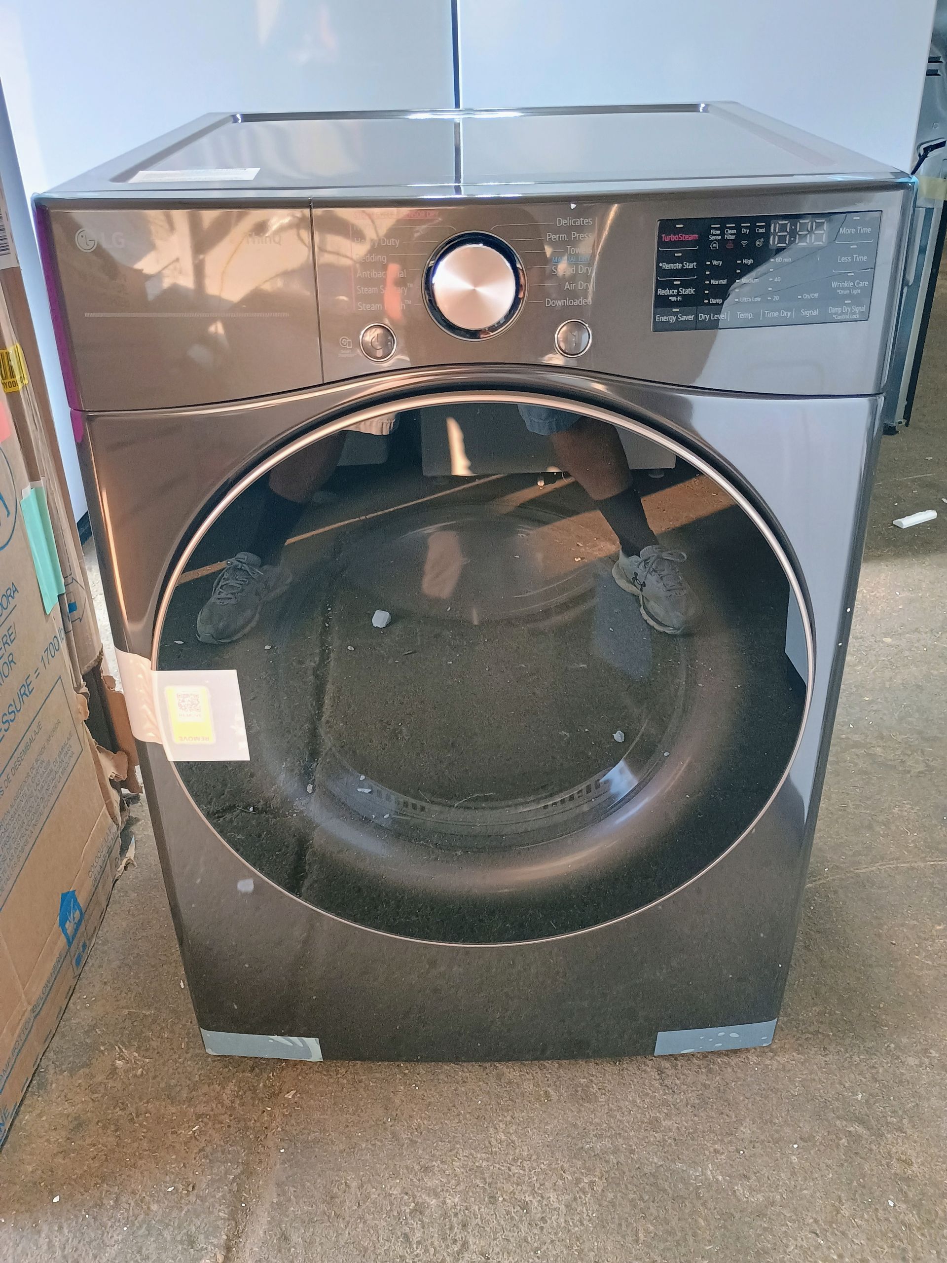 Dark gray front-load washing machine with a large round door, controls on top right, and a central knob.