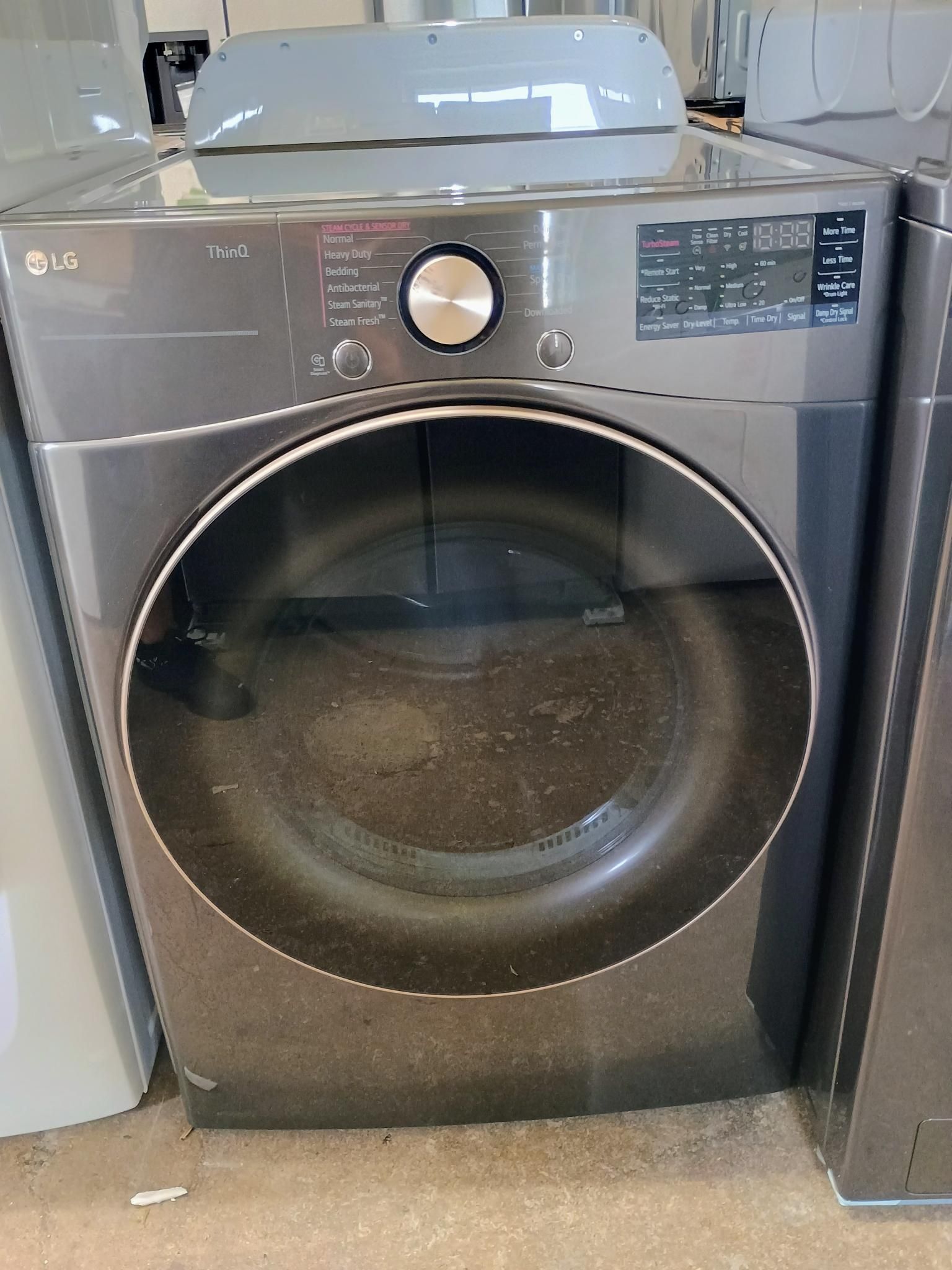An lg washer and dryer are sitting on the floor.