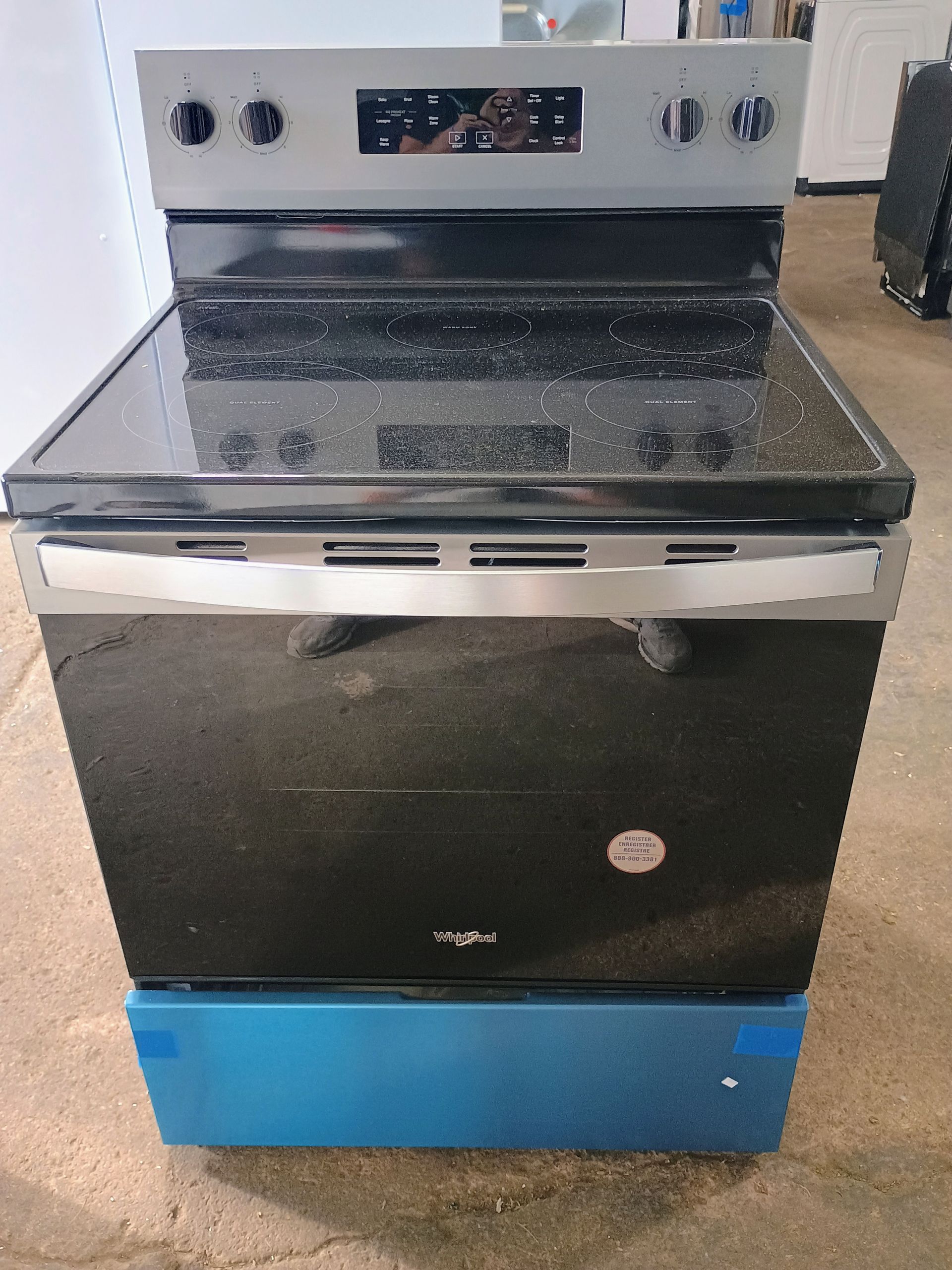 Black Whirlpool electric range on a blue base.