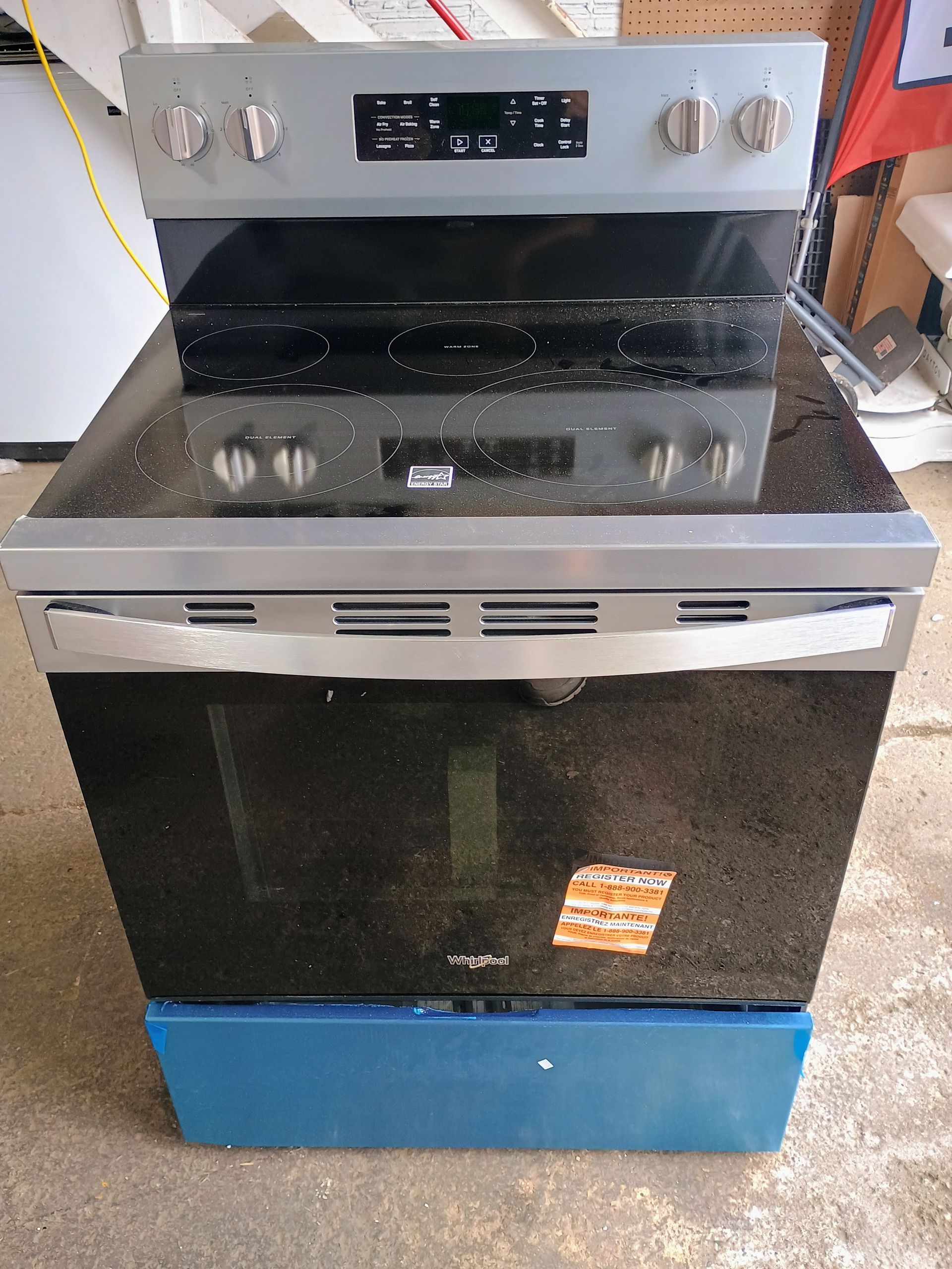 Silver and black electric range with a glass cooktop and oven.