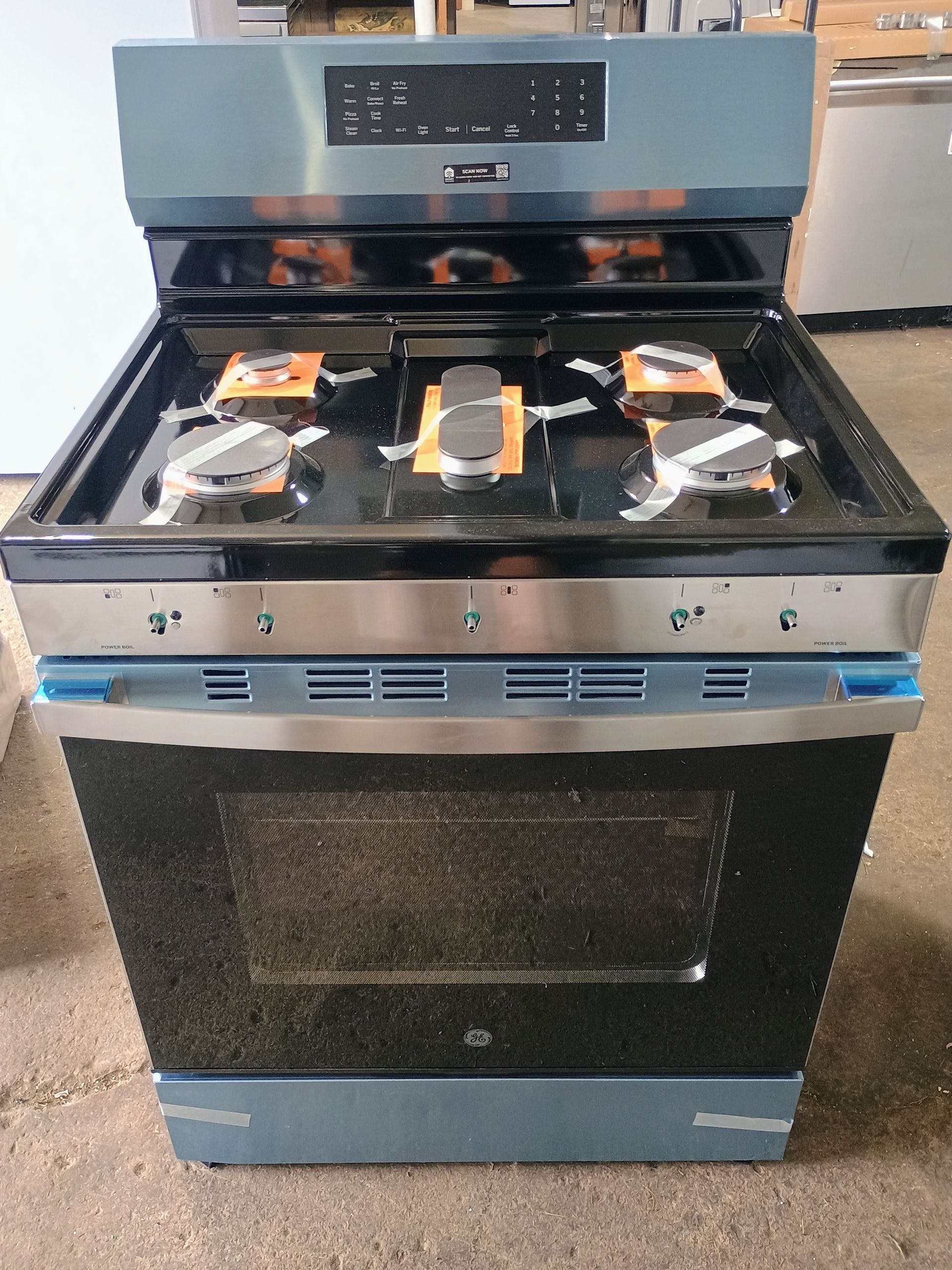 A gas range with a black cooktop and oven door. Stainless steel accents and blue accents.