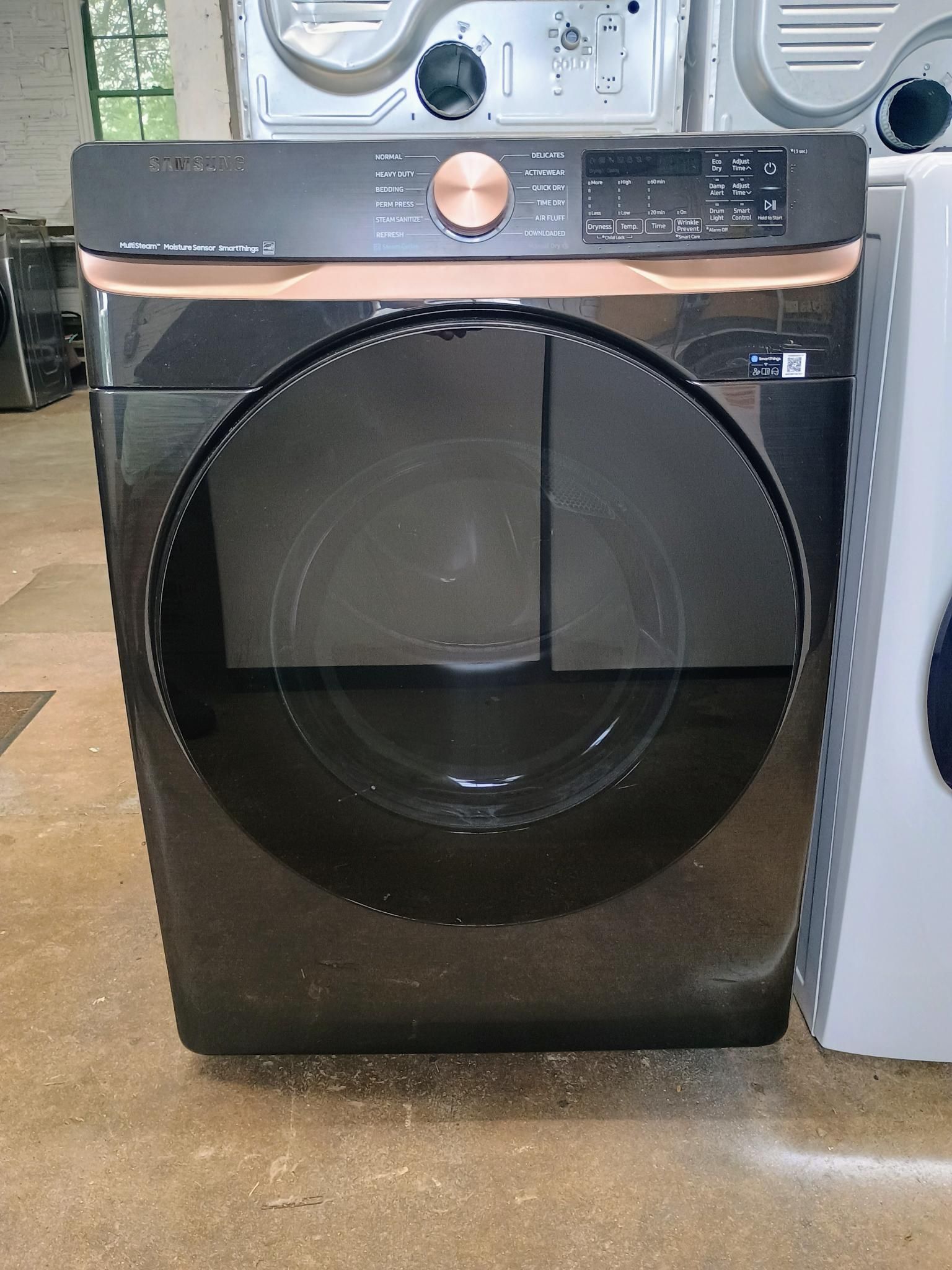 Black and copper dryer with a round door, control panel, and display screen.