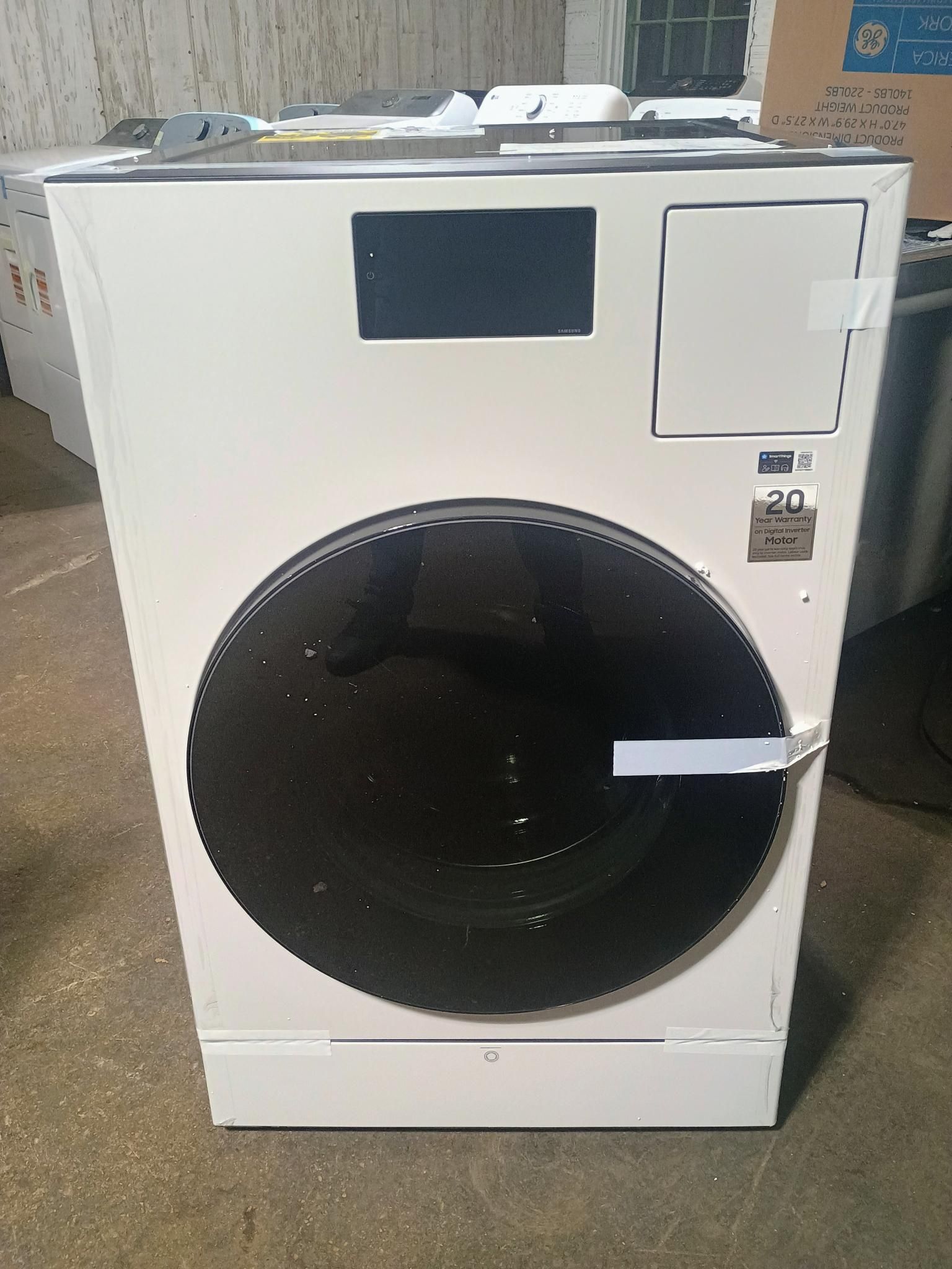 A white industrial dryer with a large black door, digital display showing 