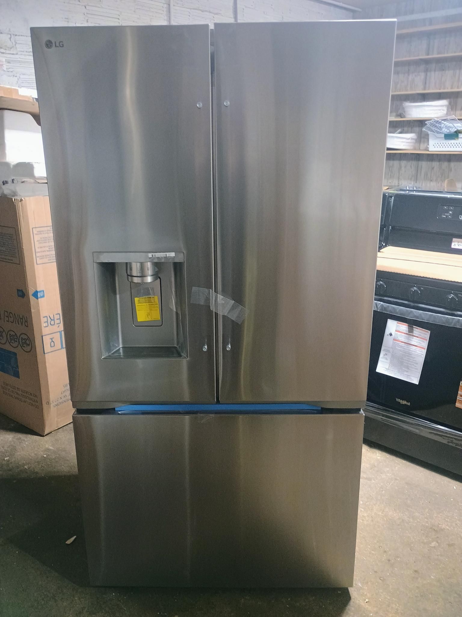 Stainless steel LG French door refrigerator with water dispenser.