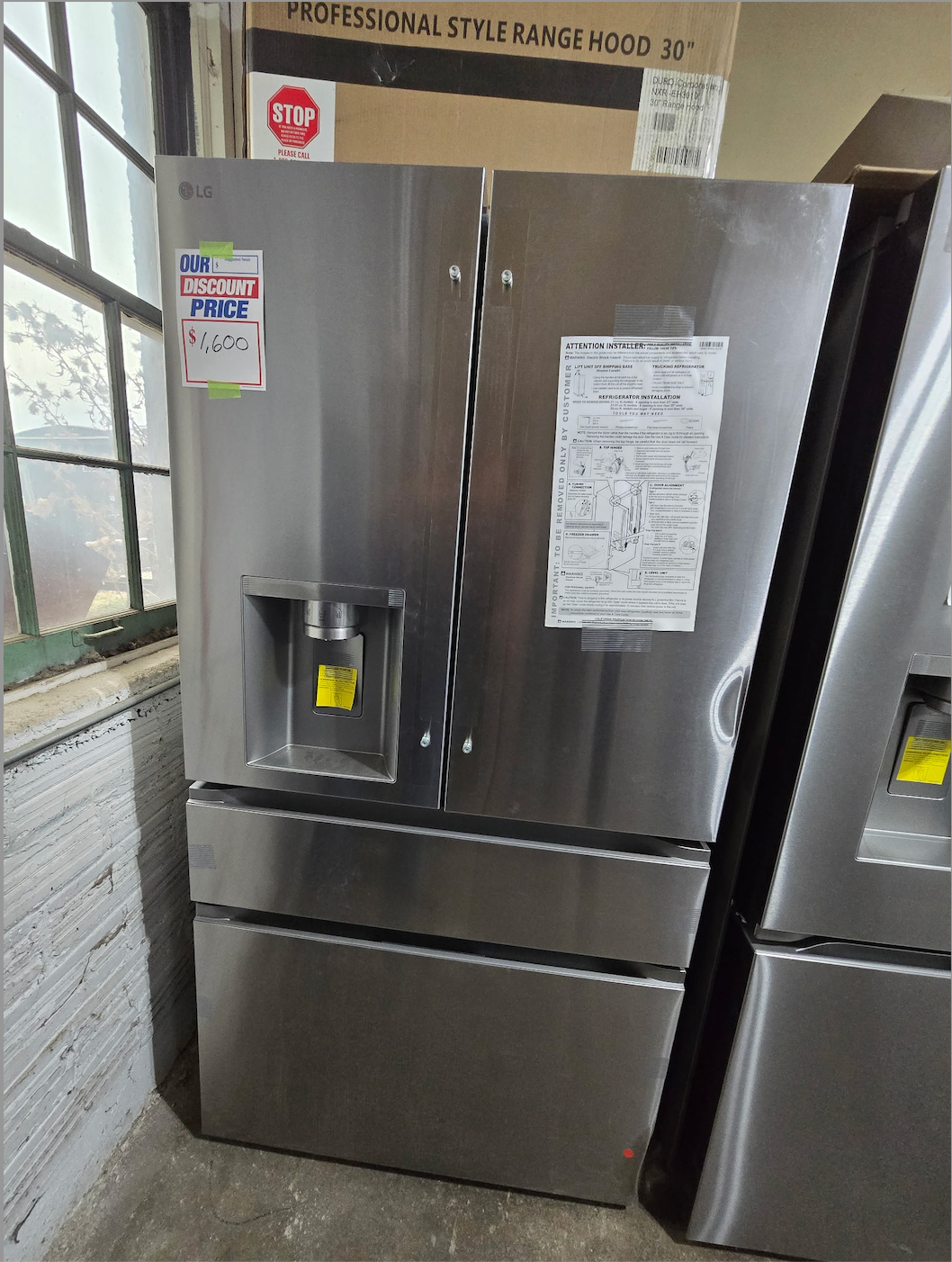 Stainless steel LG French door refrigerator with water dispenser. Two freezer drawers.